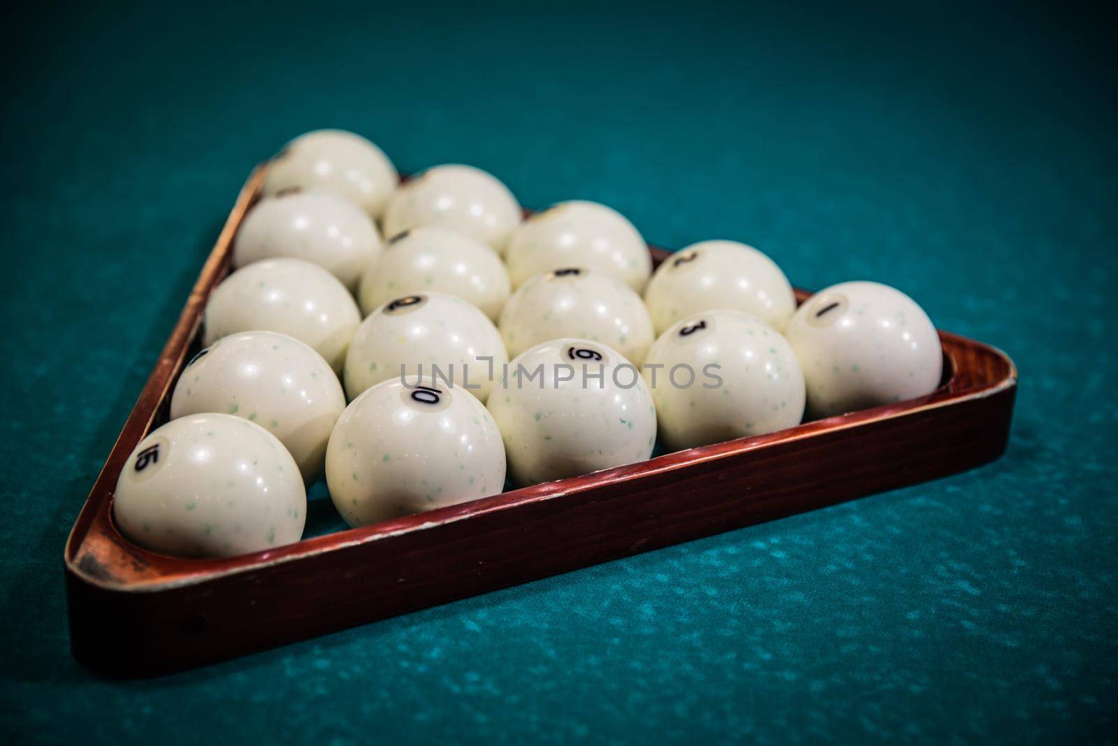 billiards balls in wooden triangle, on green felt