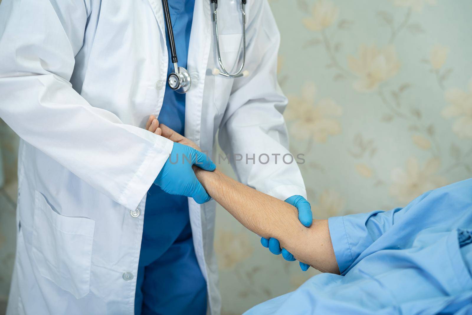 Doctor using stethoscope to checking Asian senior or elderly old lady woman patient wearing a face mask in hospital for protect infection Covid-19 Coronavirus. by pamai