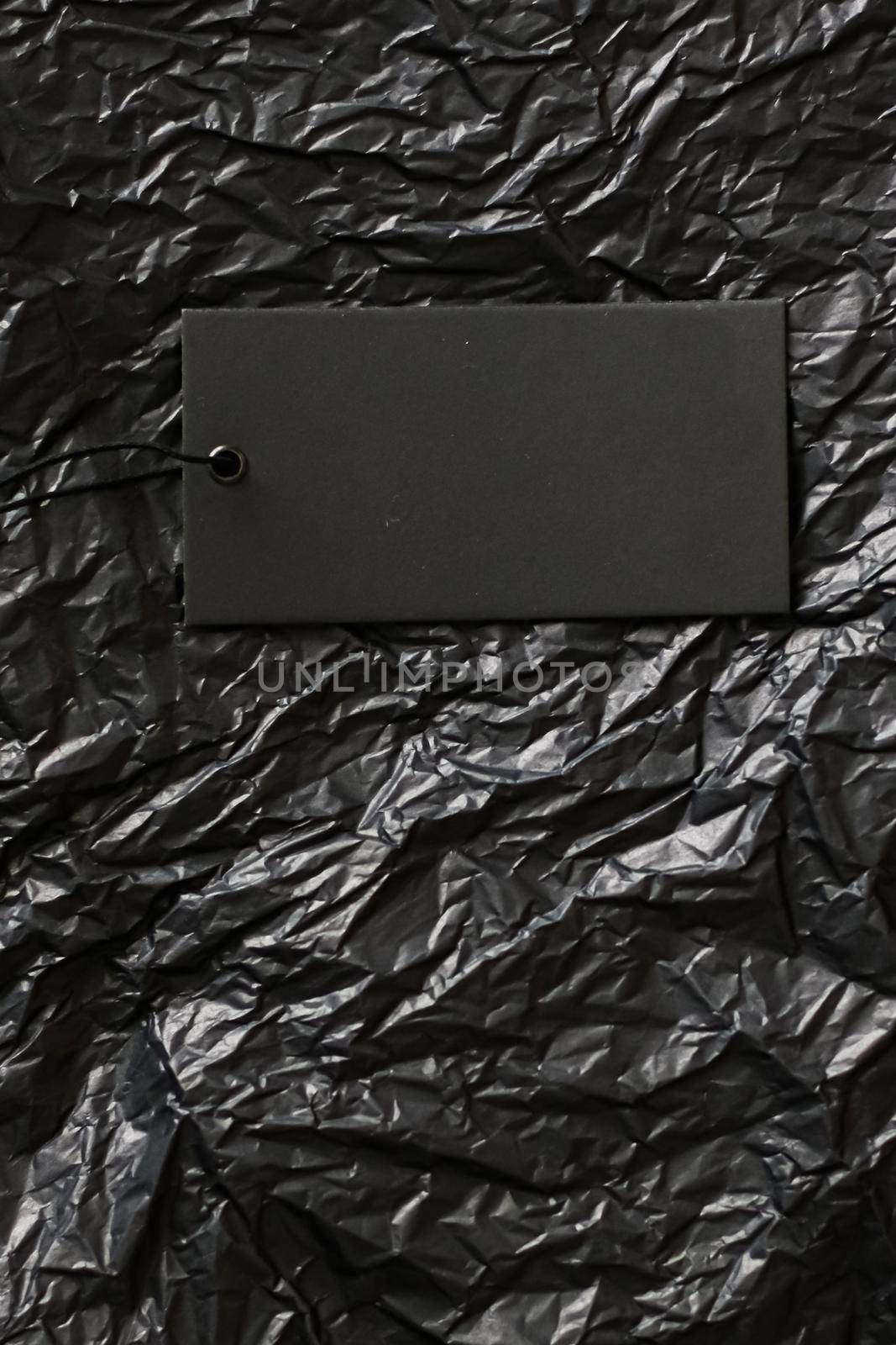 Blank price tag on black paper background.