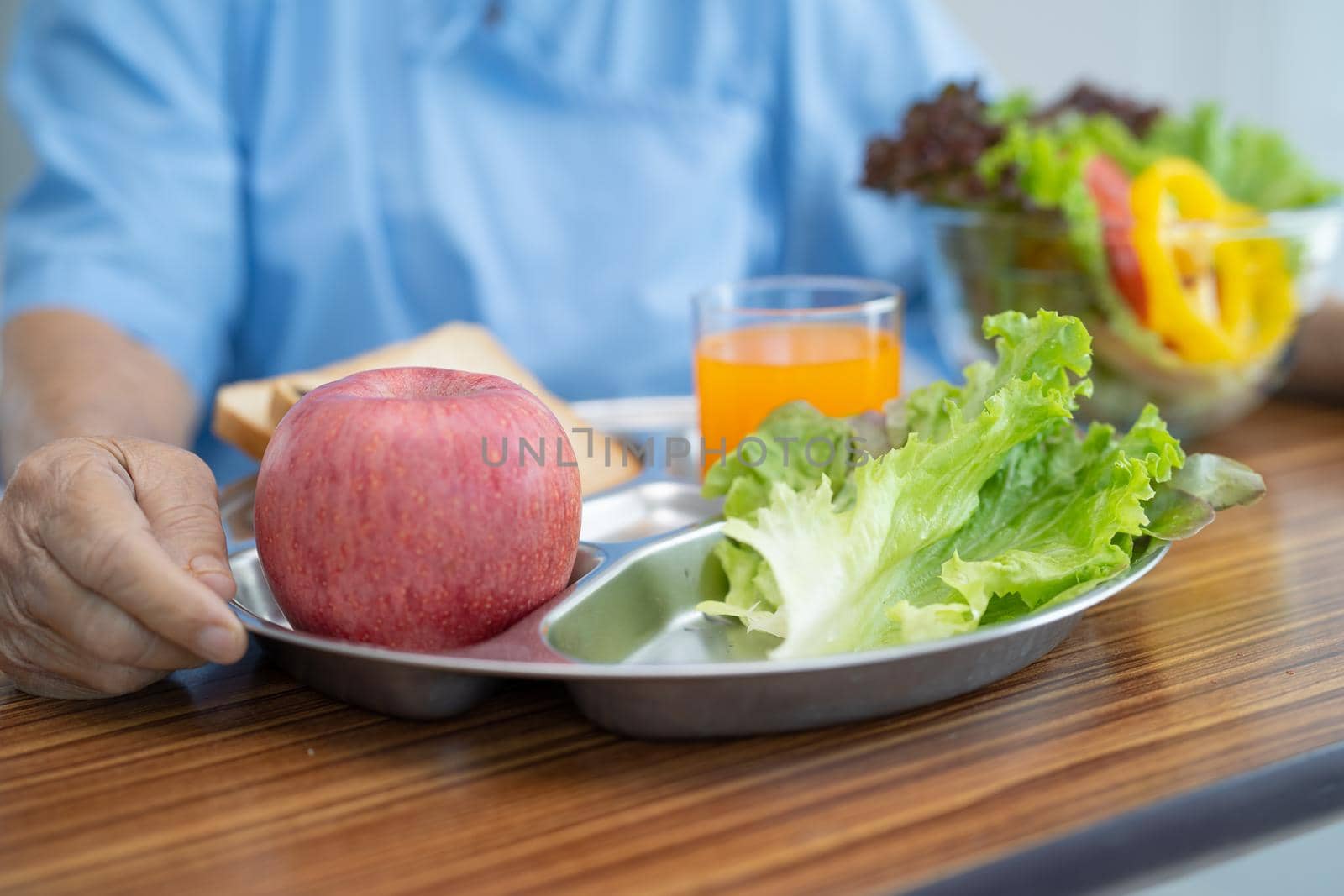 Asian senior or elderly old lady woman patient eating breakfast vegetable healthy food with hope and happy while sitting and hungry on bed in hospital. by pamai