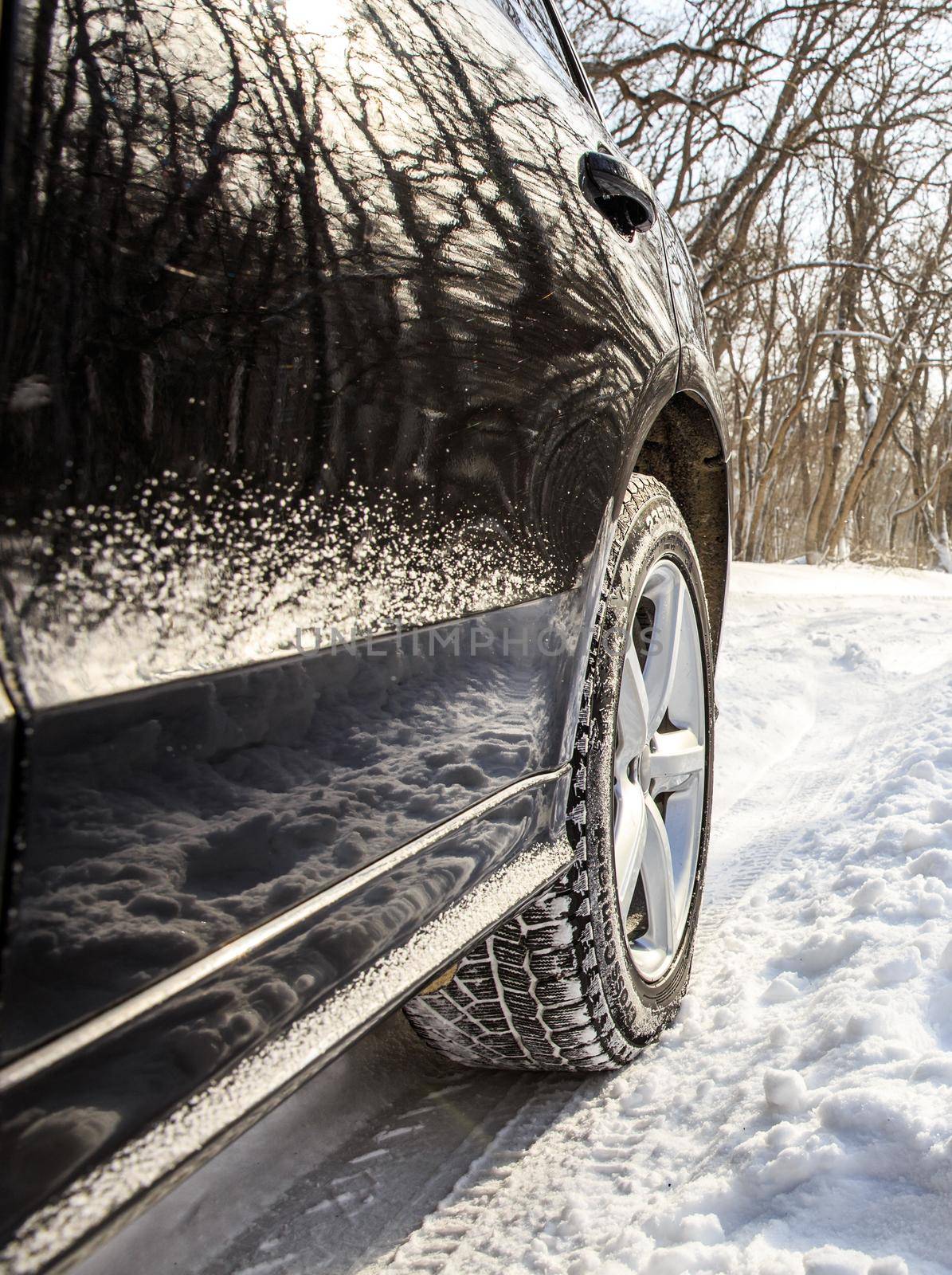 Driving SUV car in winter on forest road with much snow