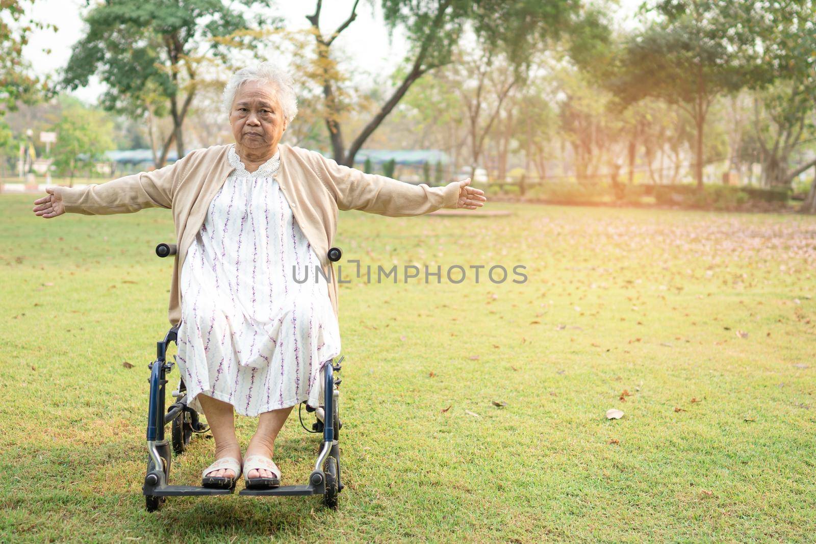 Asian senior or elderly old lady woman patient exercise on wheelchair with happy fresh enjoy in park, healthy strong medical concept by pamai