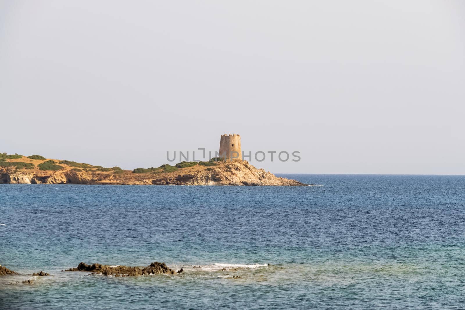 Beautiful view of the southern Sardinian sea. Note the historic Saracen tower on the rock formations.