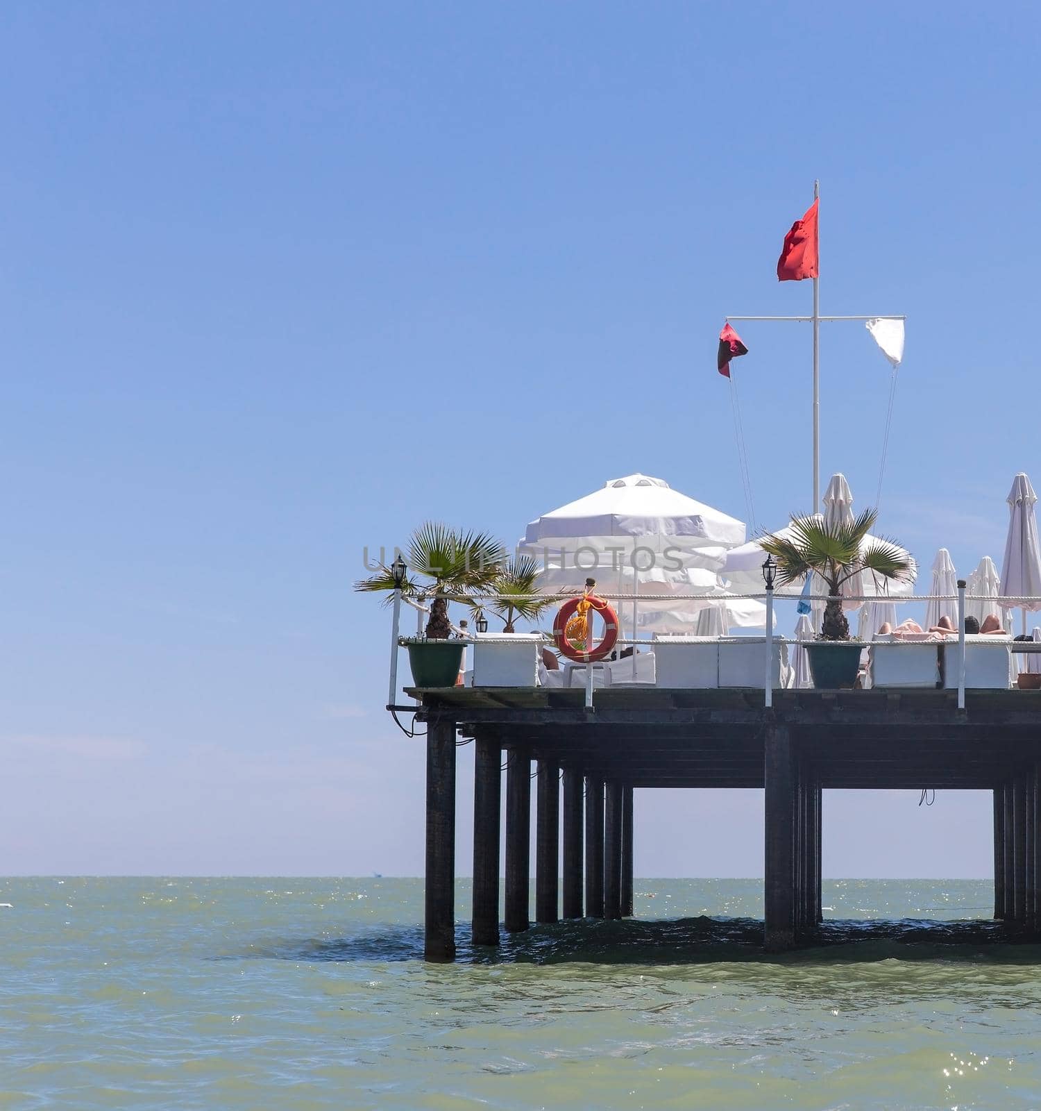 Pier on a sea with comfortable white armchairs