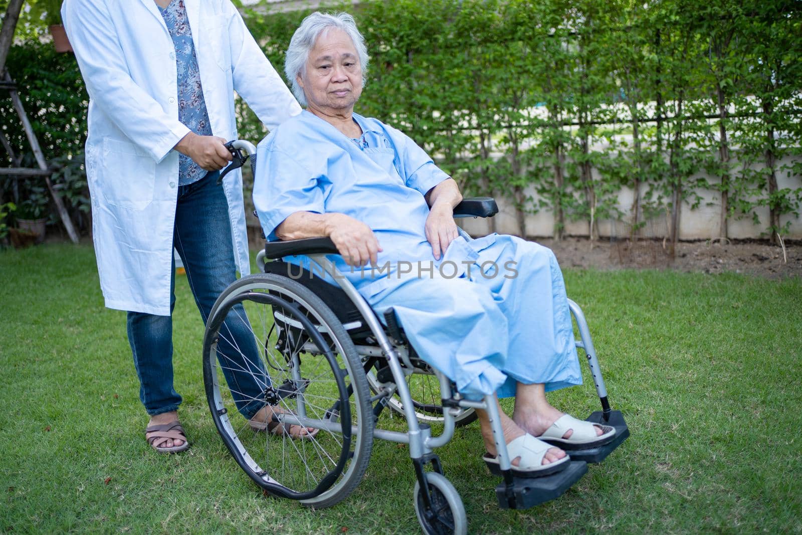 Doctor help and care Asian senior or elderly old lady woman patient sitting on wheelchair at park in nursing hospital ward, healthy strong medical concept.