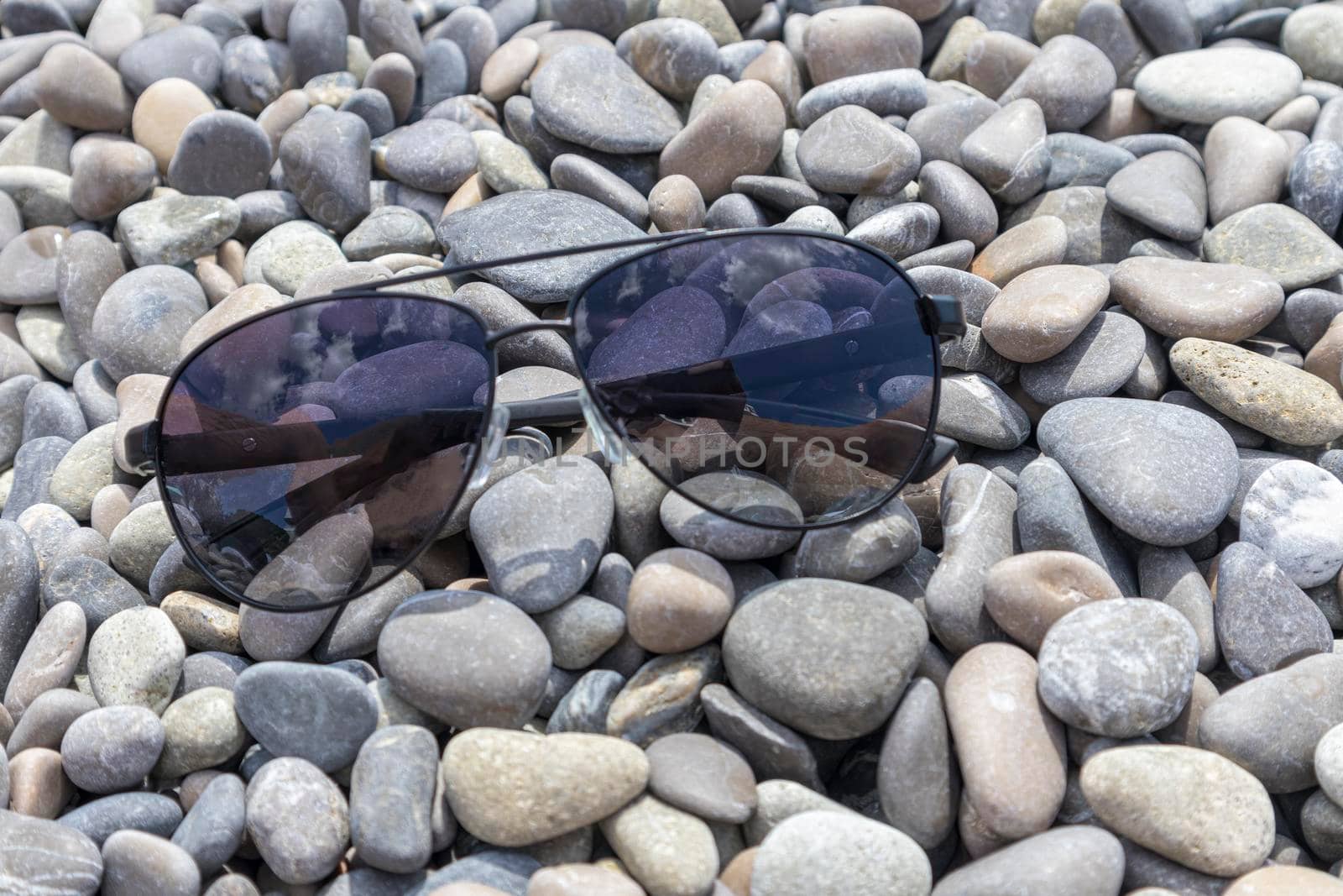sunglasses on sea pebbles close-up as a background. High quality photo