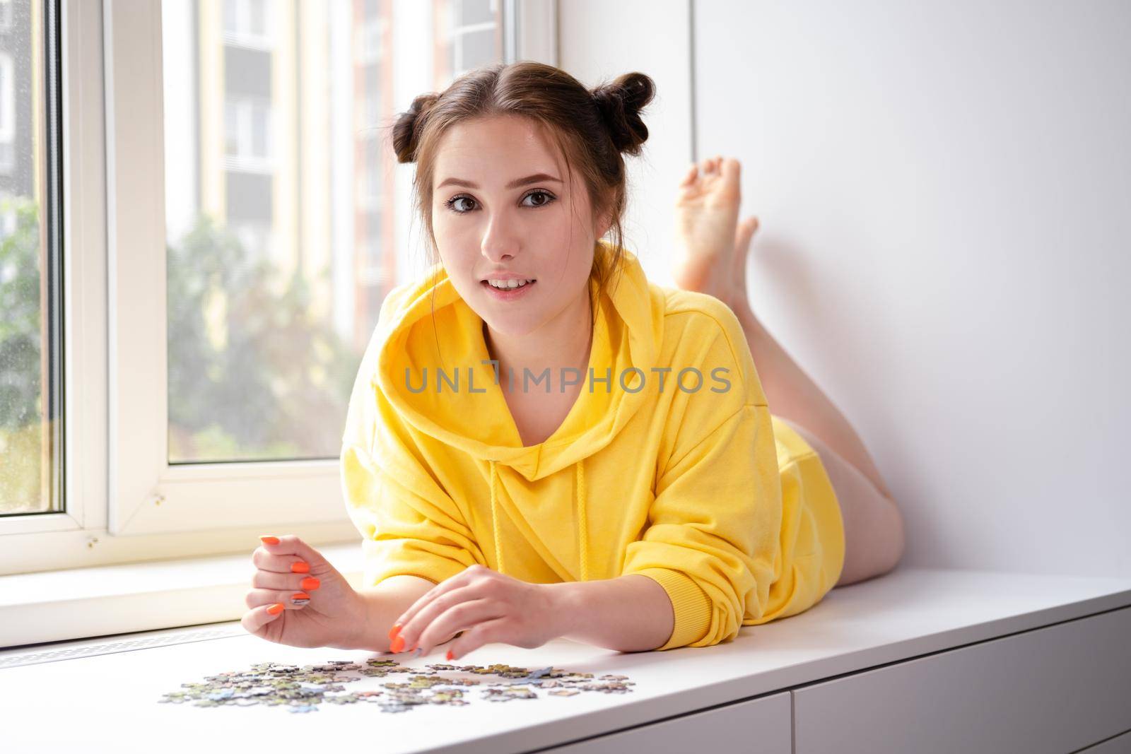 Young Woman trying to match pieces of a Jigsaw Puzzle Game. Playing board game