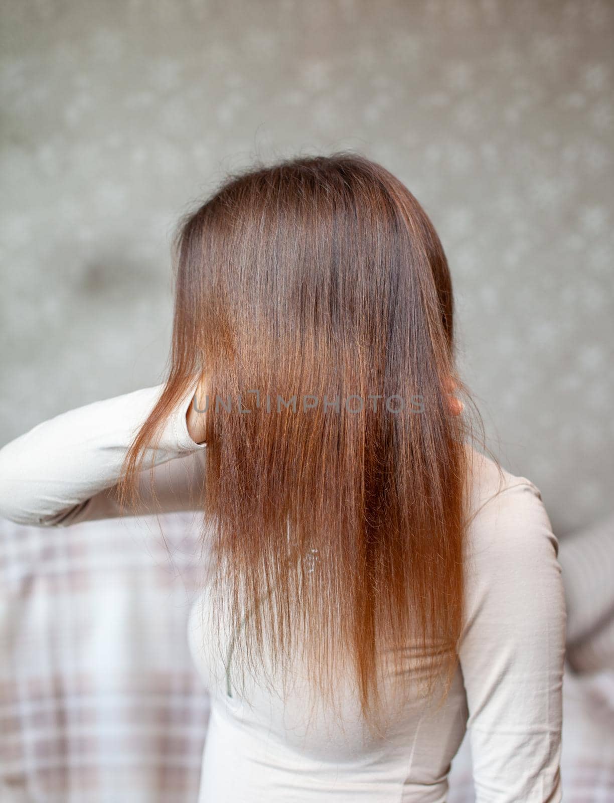 A girl with long, straight and beautiful brown hair. Hair care at home.