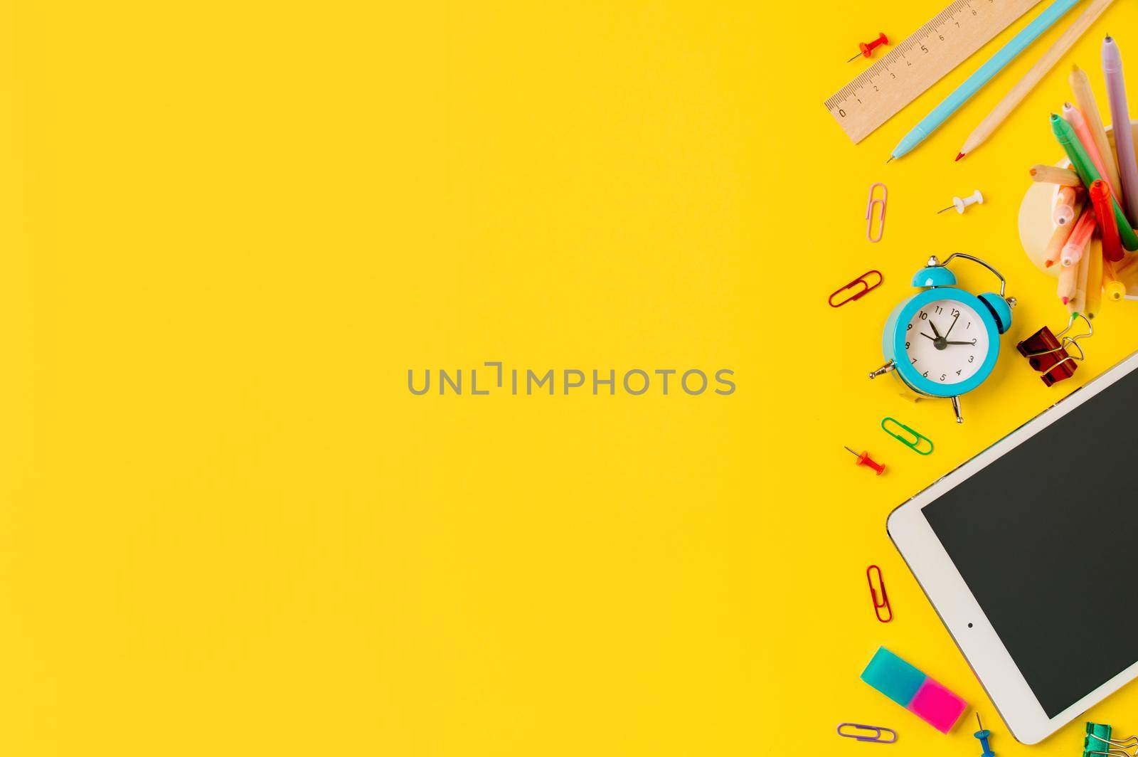 Back to school, online study, distantly learning class concept. Creative student desk with tablet pc and colorful modern school supplies on yellow background. Top view Flatlay. Copy space