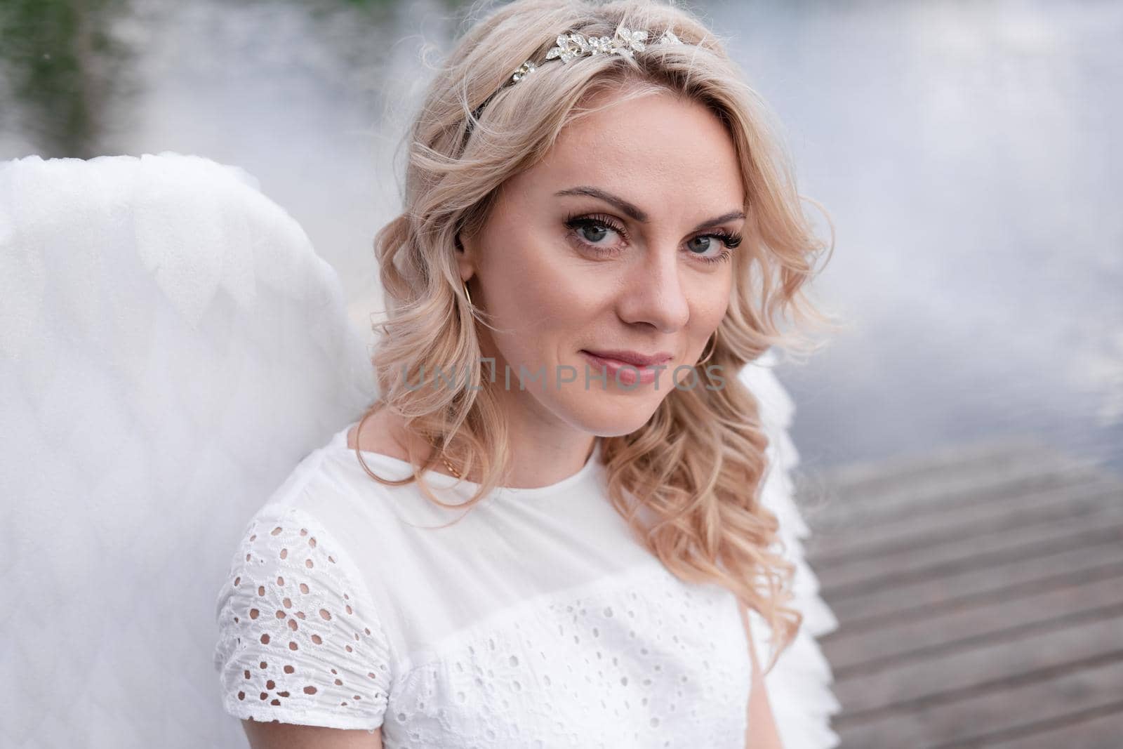 portrait of blonde woman in white dress and white angels wings. good people. heaven, god. paradise angel.