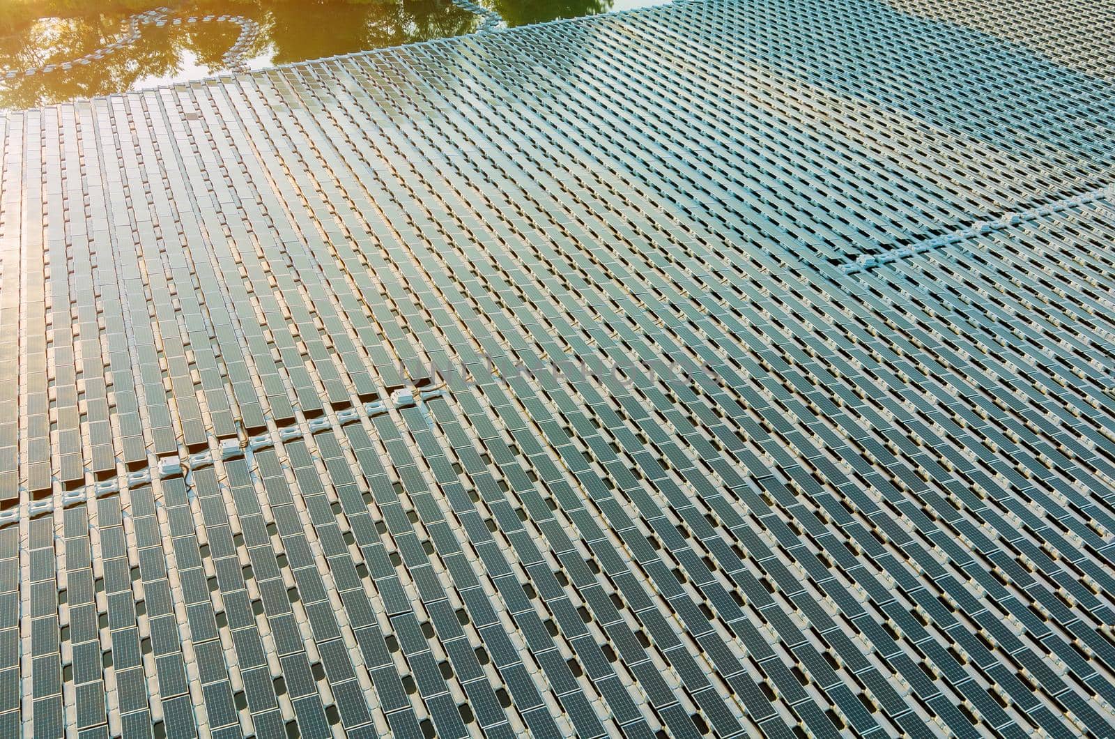 Aerial top view of solar panels cells on floating in pond the power plant with water, renewable energy source by ungvar