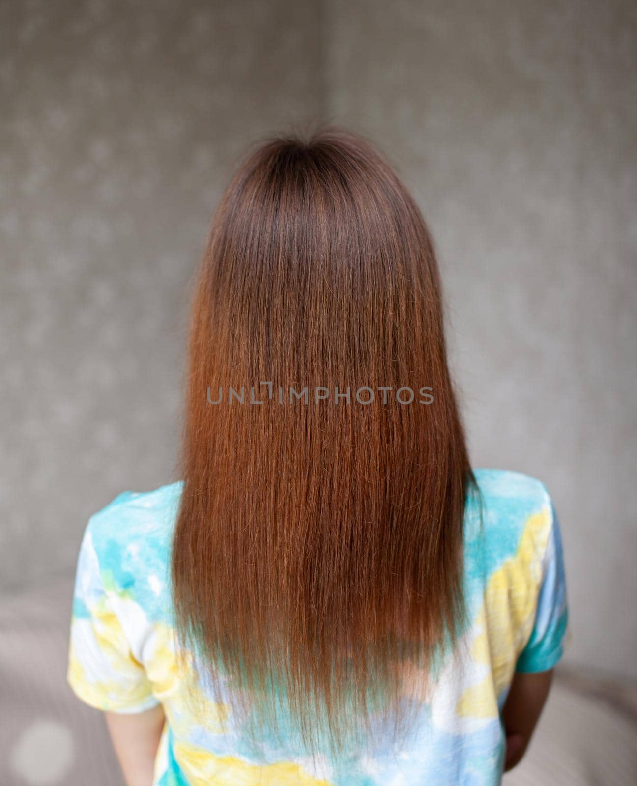 A girl with long, straight and beautiful brown hair. Hair care at home.