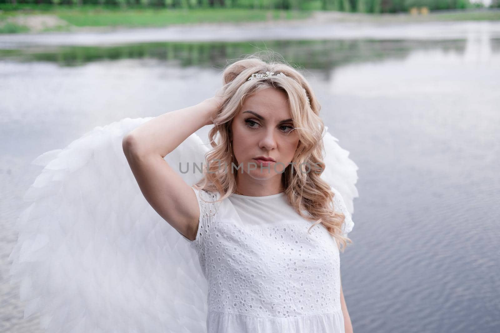 portrait of blonde woman in white dress and white angels wings. good people. heaven, god. paradise angel.