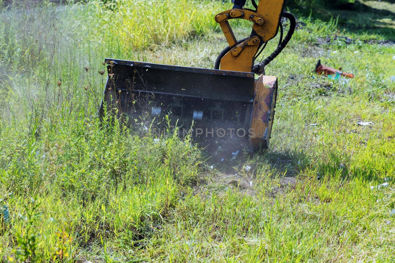 Wheeled tractor lawn mower with a external detachable mounted mower equipment driving on roadside of a suburban highway by ungvar