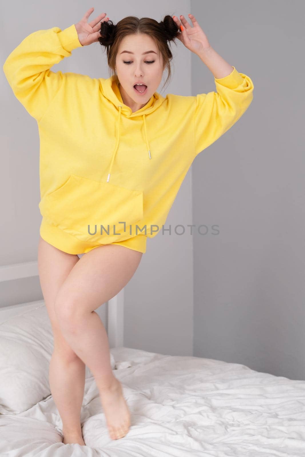 happy positive brunette in yellow hoodie in bright room. happy people. millennial generation. fashionable teenager. trendy colours by oliavesna