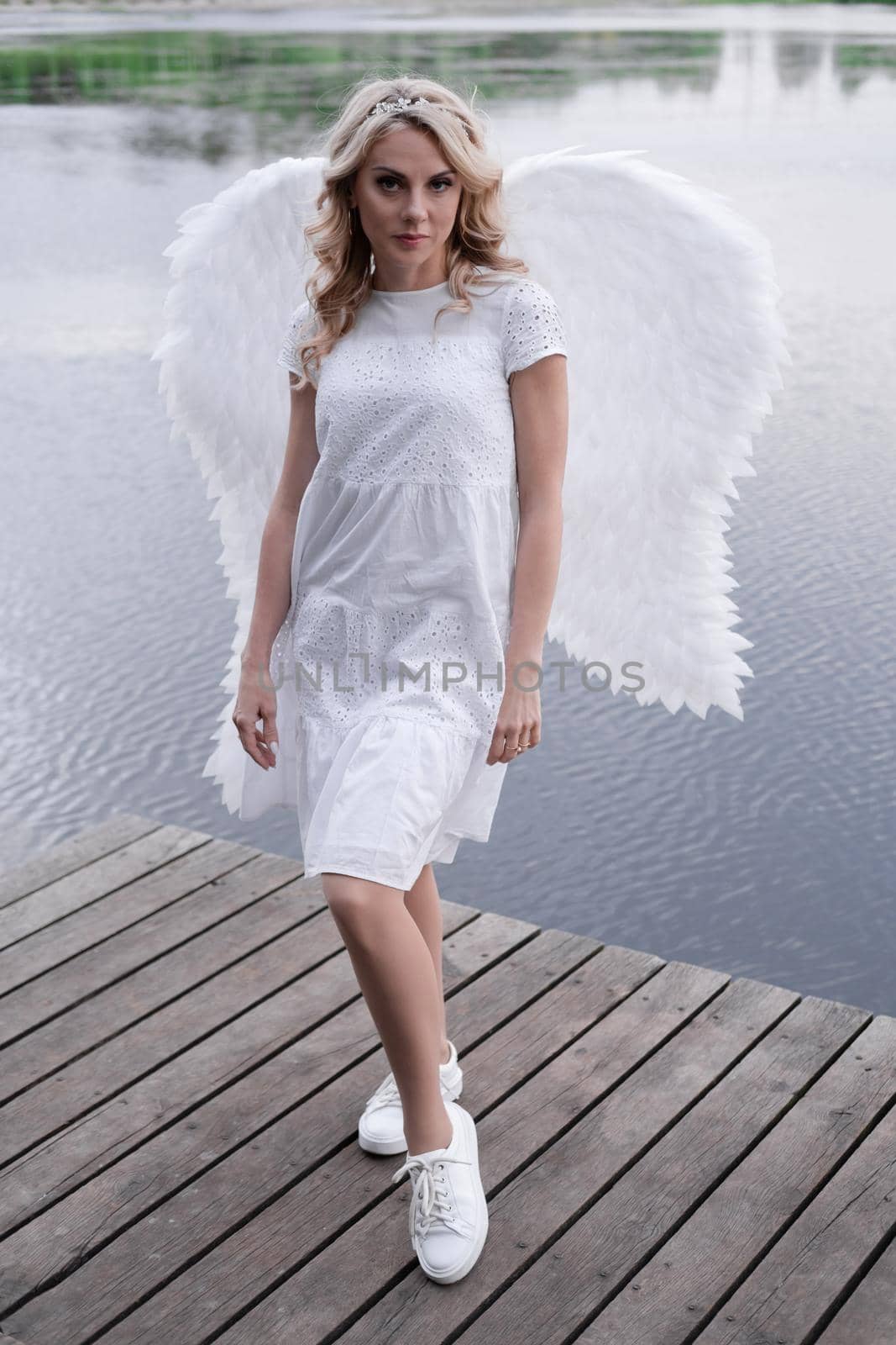 portrait of blonde woman in white dress and white angels wings. good people. heaven, god. paradise angel.