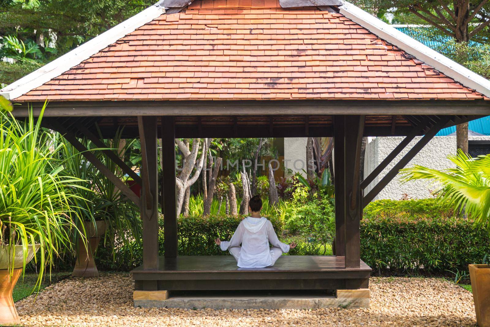 Woman in gazebo practicing yoga in Thailand