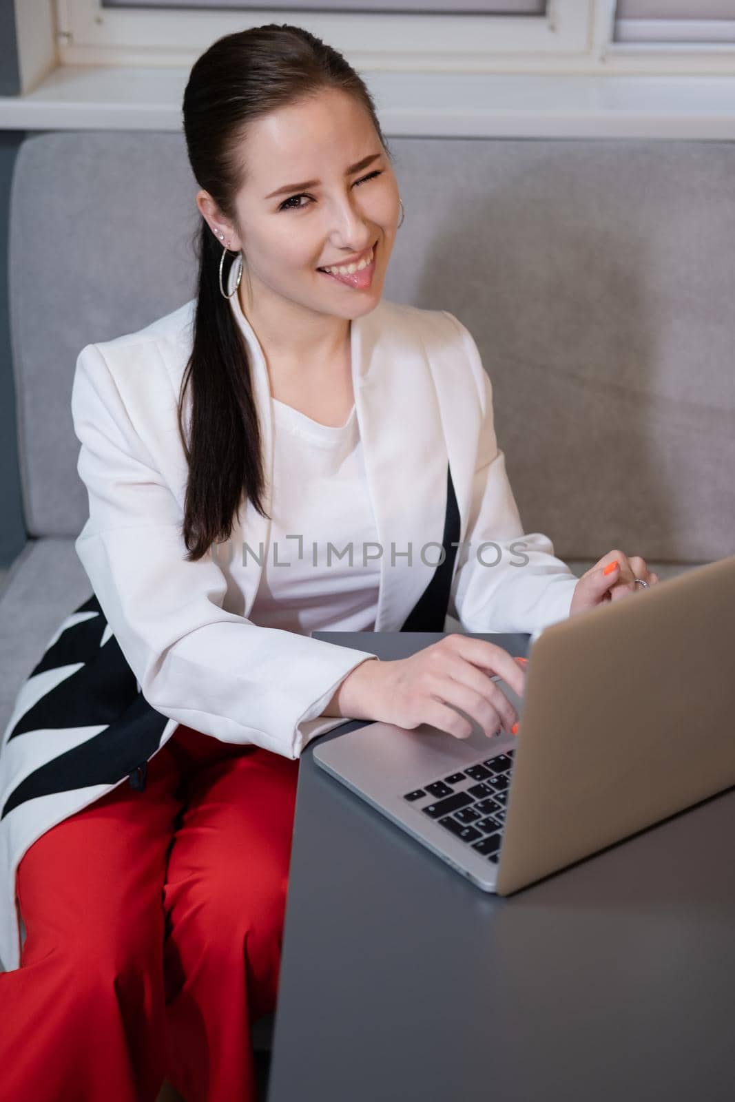 brunette woman use laptop in grey room. freelancer. working from home. student, remote study by oliavesna