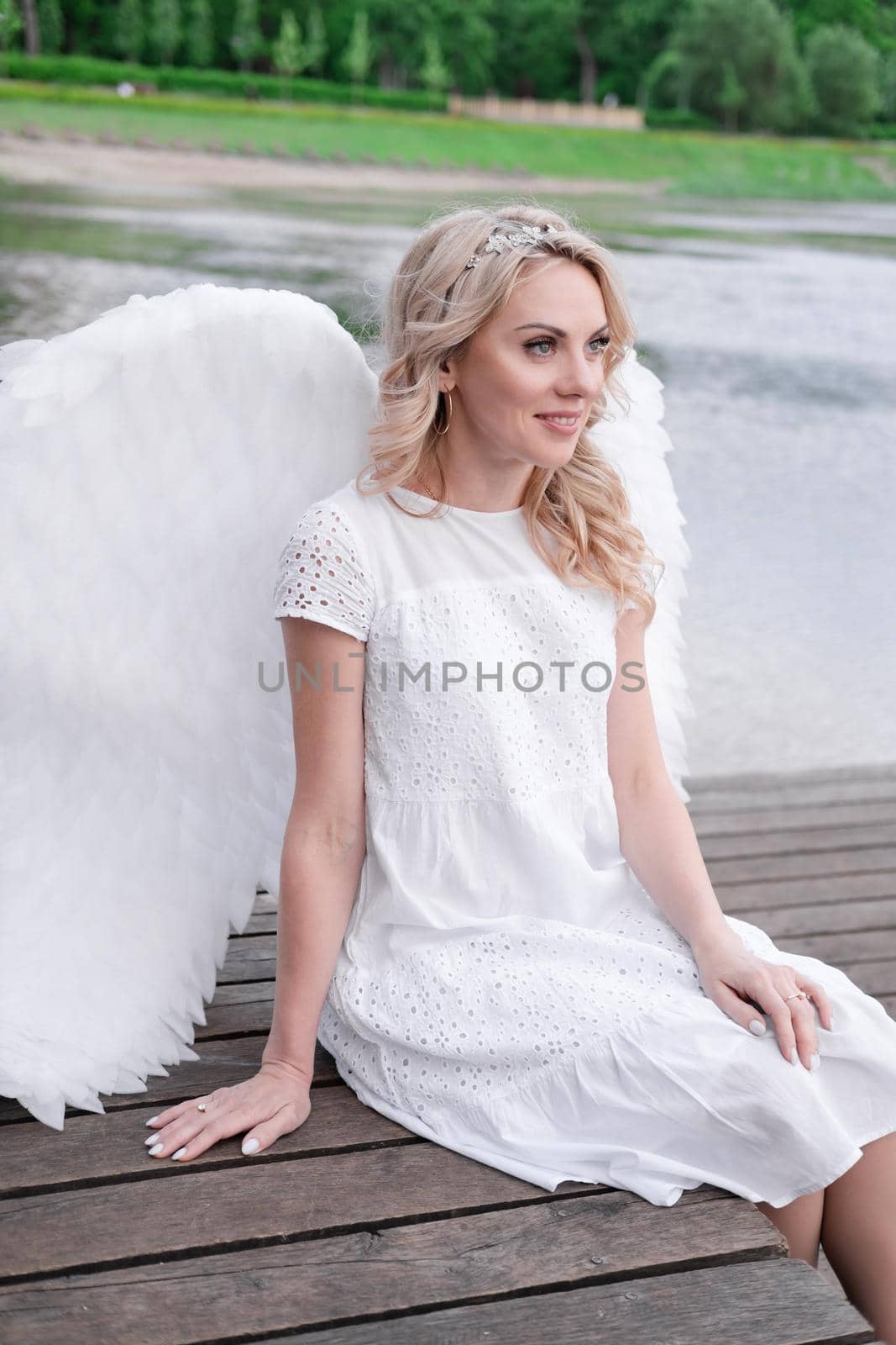 portrait of blonde woman in white dress and white angels wings. good people. heaven, god. paradise angel.