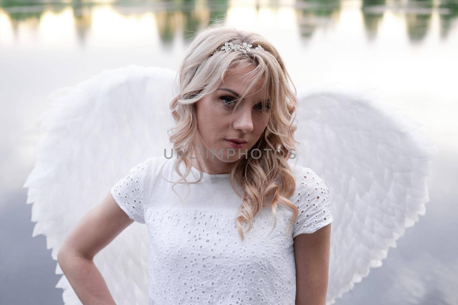 portrait of blonde woman in white dress and white angels wings. good people. heaven, god. paradise angel.