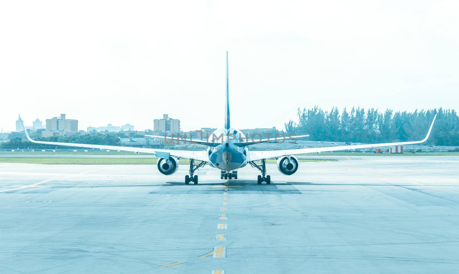 Back view of airplane standing on runway at aerodrome