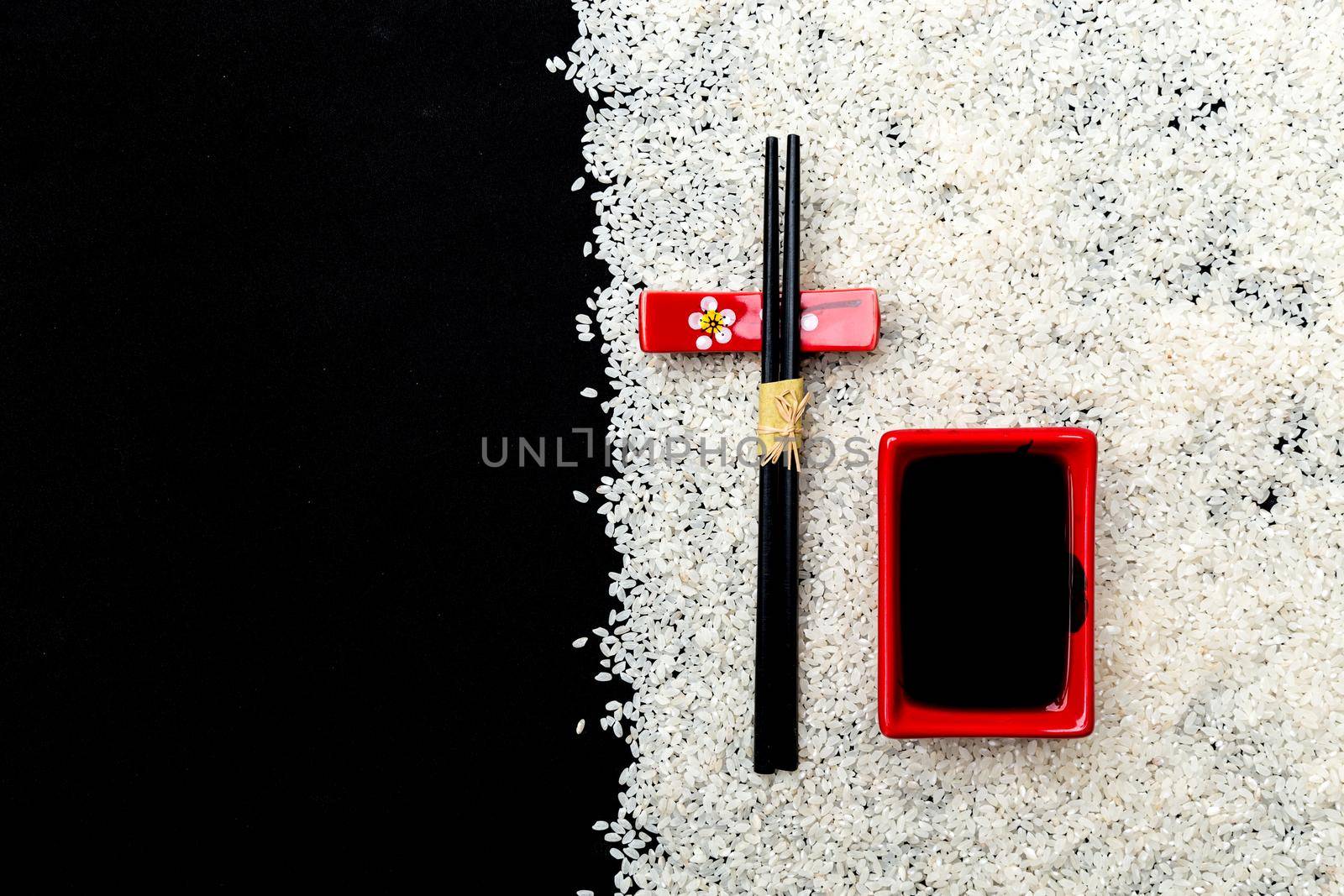 Japanese cuisine table setting with rice background and chopsticks