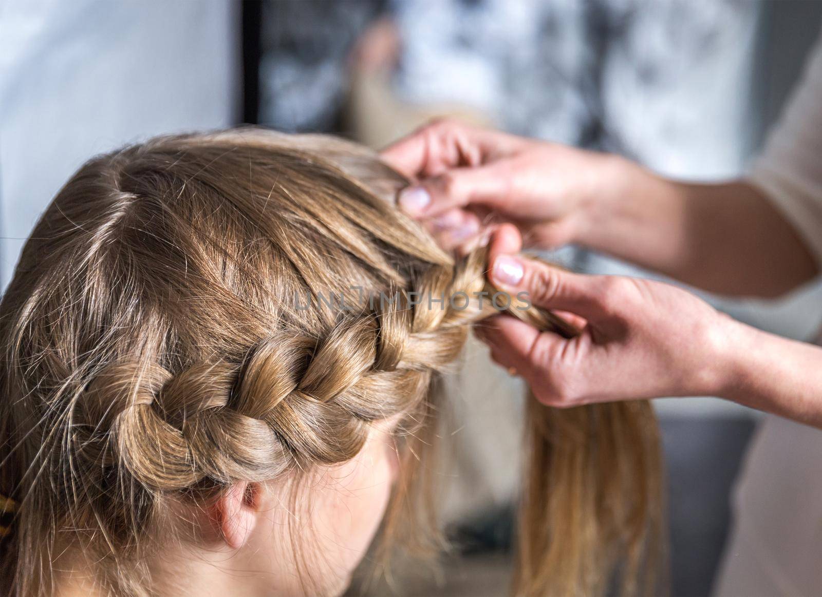 Hairdresser make braid in beauty salon