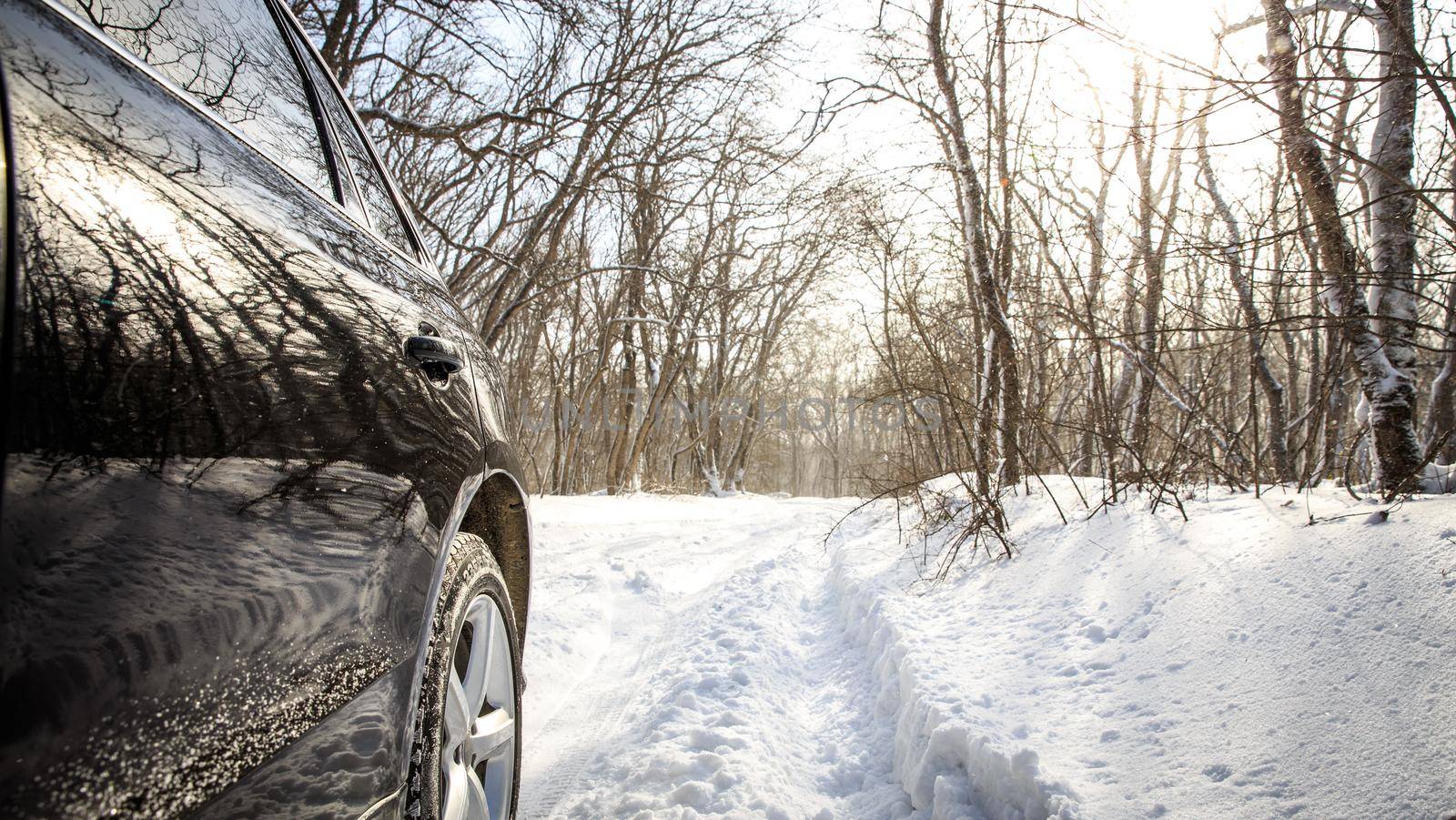 Driving SUV car in winter on forest road with much snow