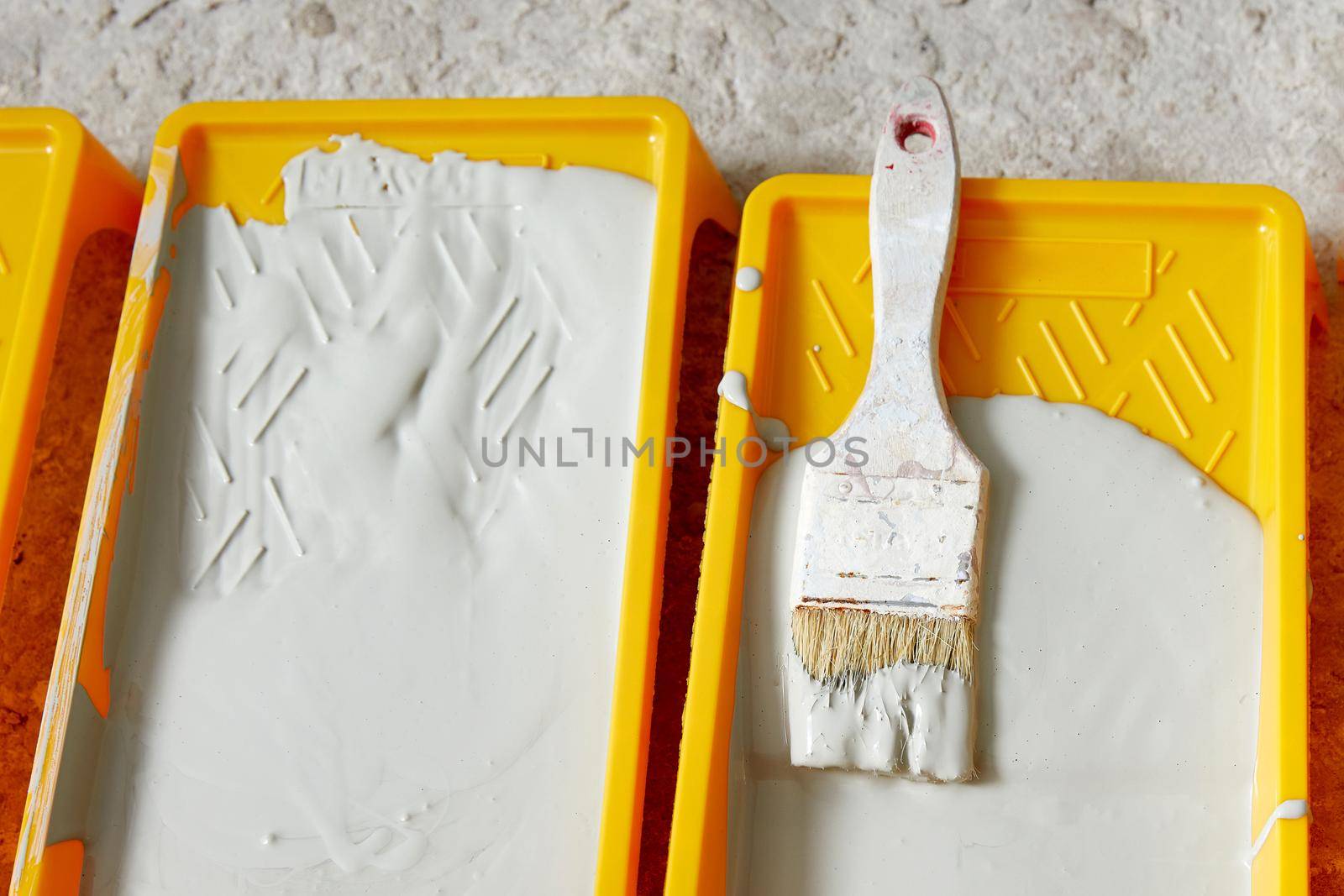 Closeup view of paint tray filled with gray paint. Tools for the painter and redecoration. Interior renovation concept