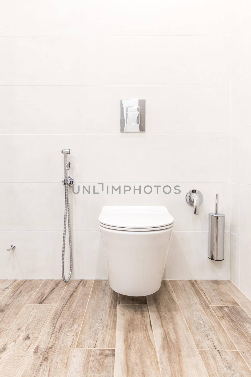 Toilet bowl in modern bathroom with wooden floor