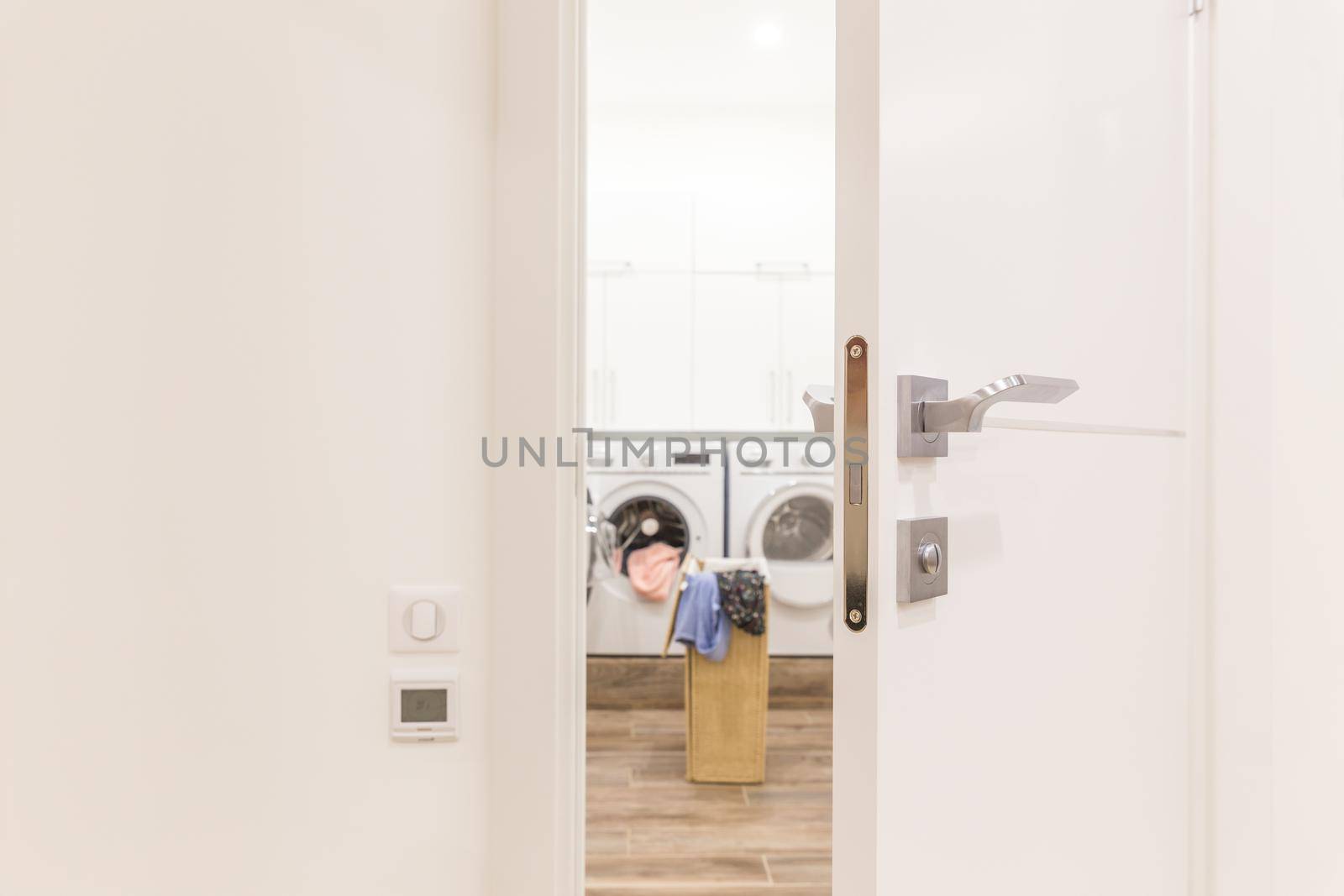 View through door to laundry room with basket and washing machine