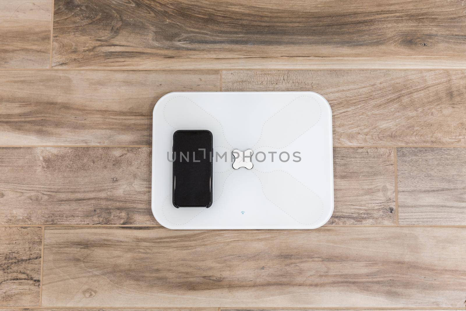Smart scale standing on a floor connected to smartphone