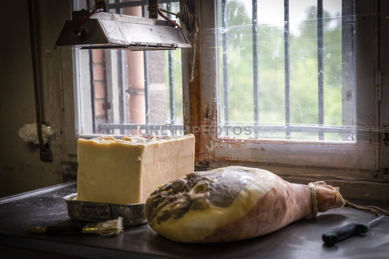 Greasing hams with lard before hanging them to dry