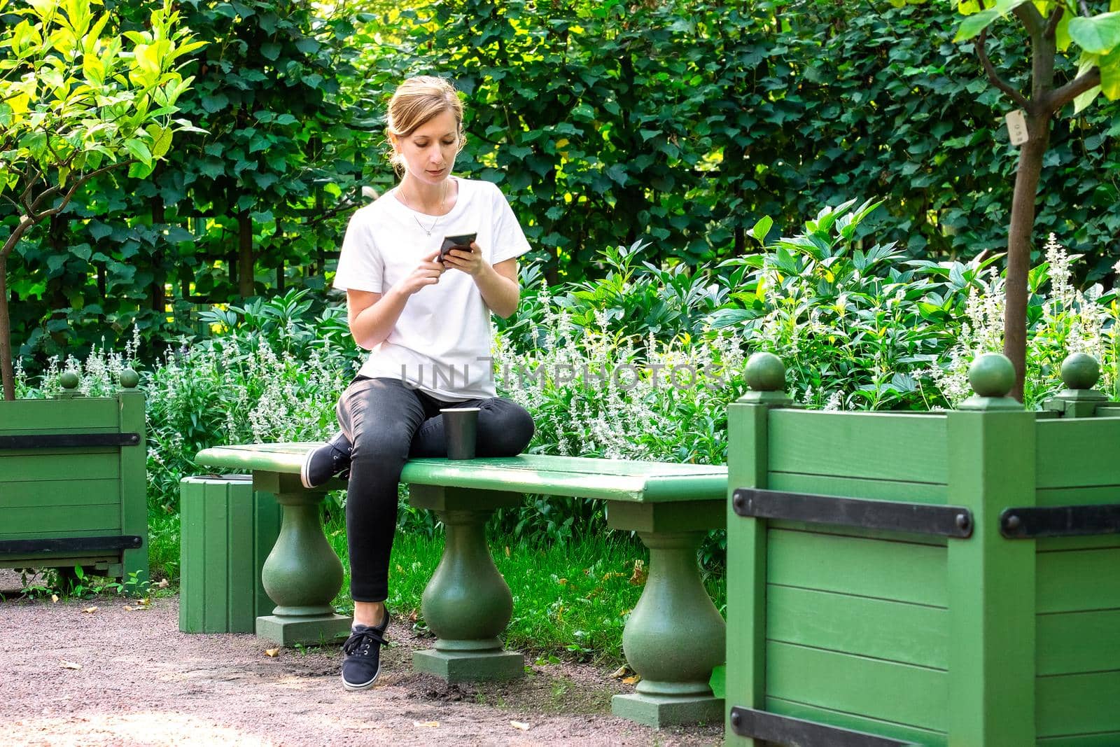 Woman looks at smartphone screen and reads message from social media. by OlgaGubskaya