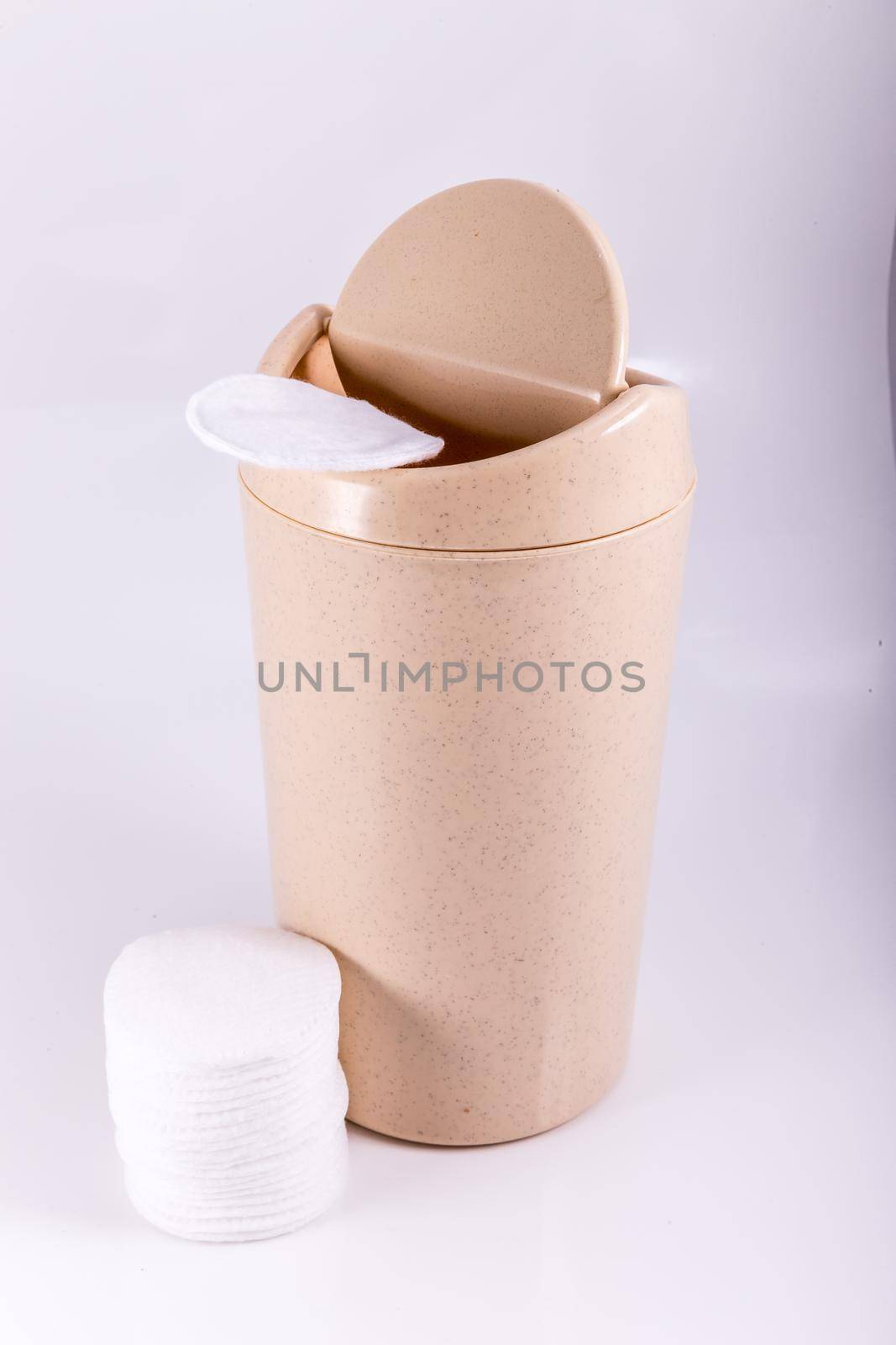 Plastic beige trash bin isolated on white background