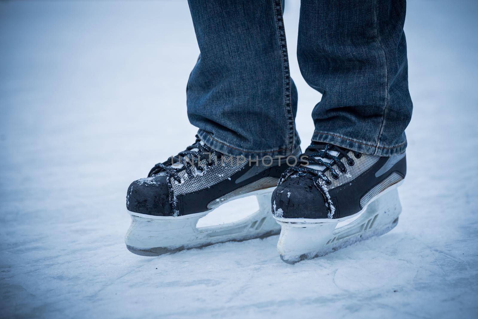 man wearing hockey skaters on ice rink