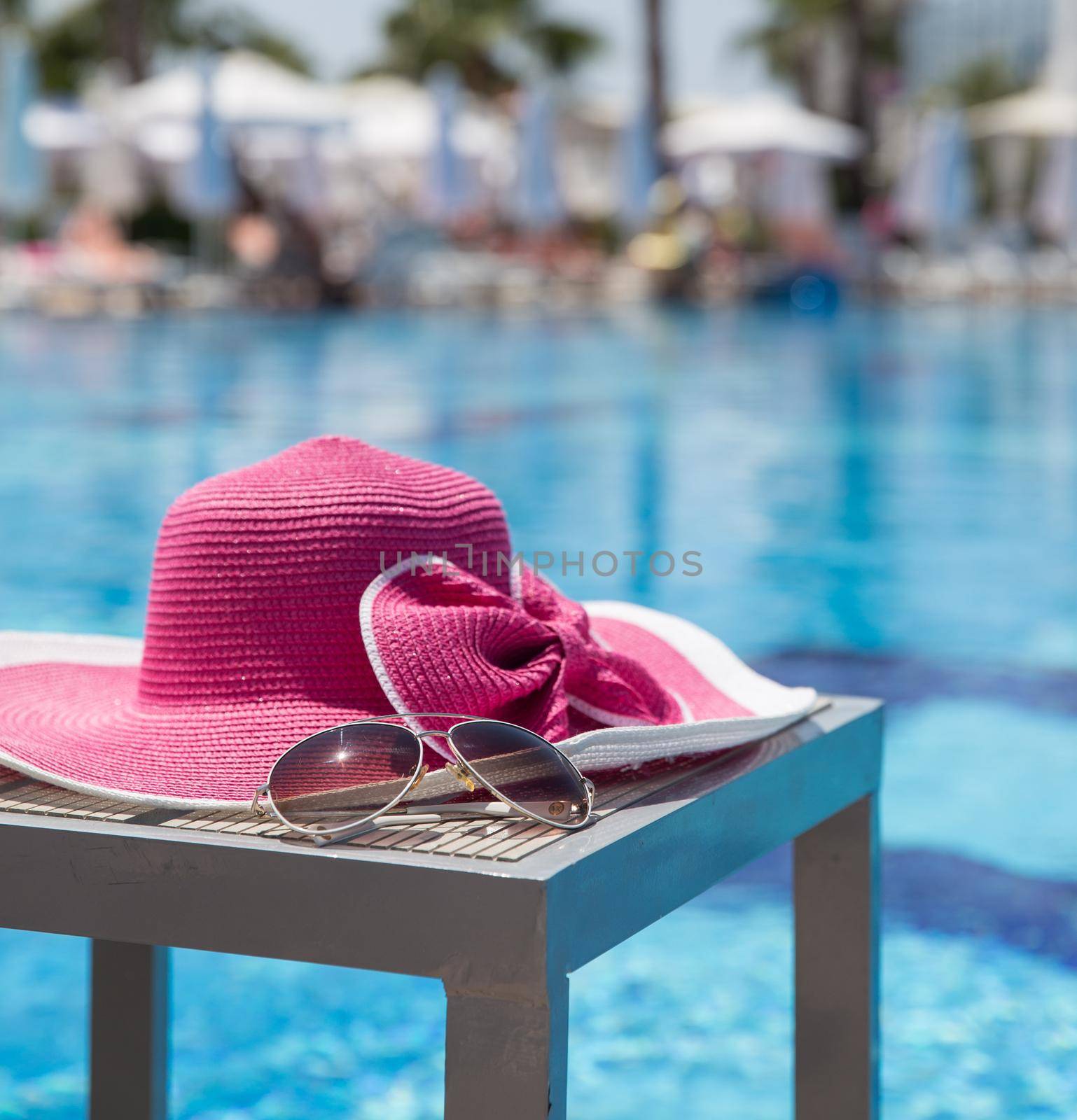 Nice pink hat with a bow near the pool