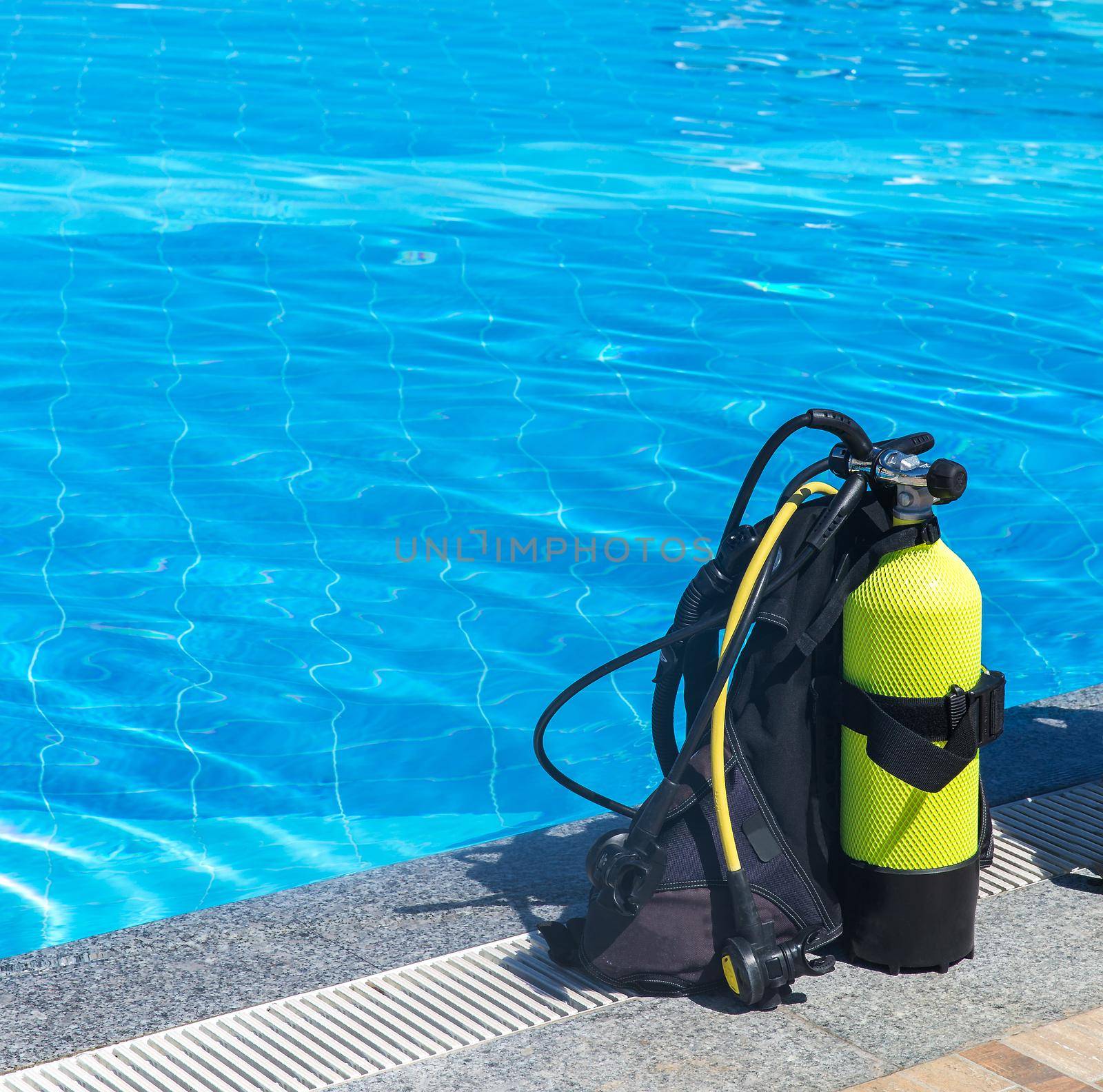 Set of scuba gear set up at the edge of a swimming pool