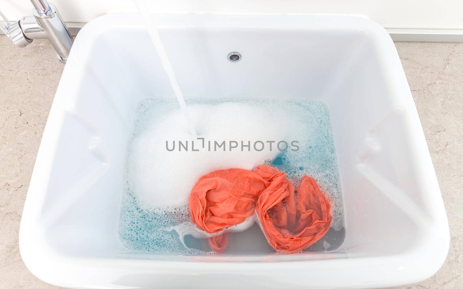 Washing clothes in sink in laundry room