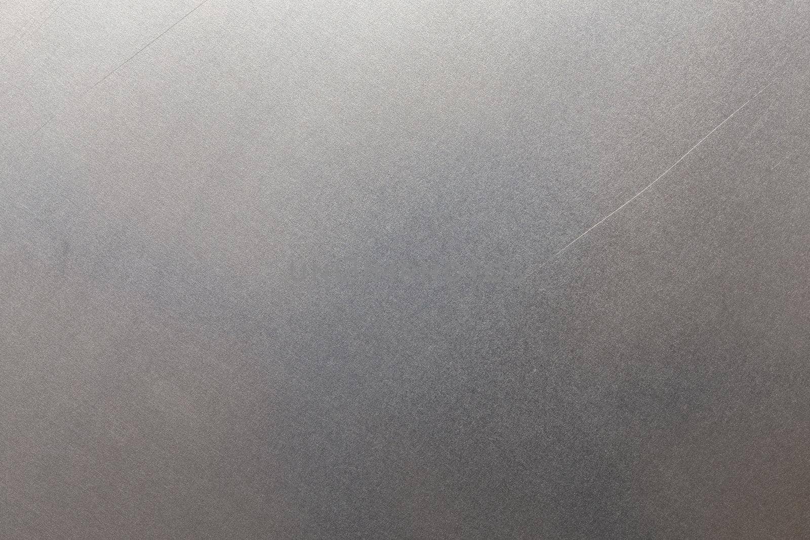 Uncoated flat cold rolled metal sheet surface with few minor scratches. Close-up in directly above composition.