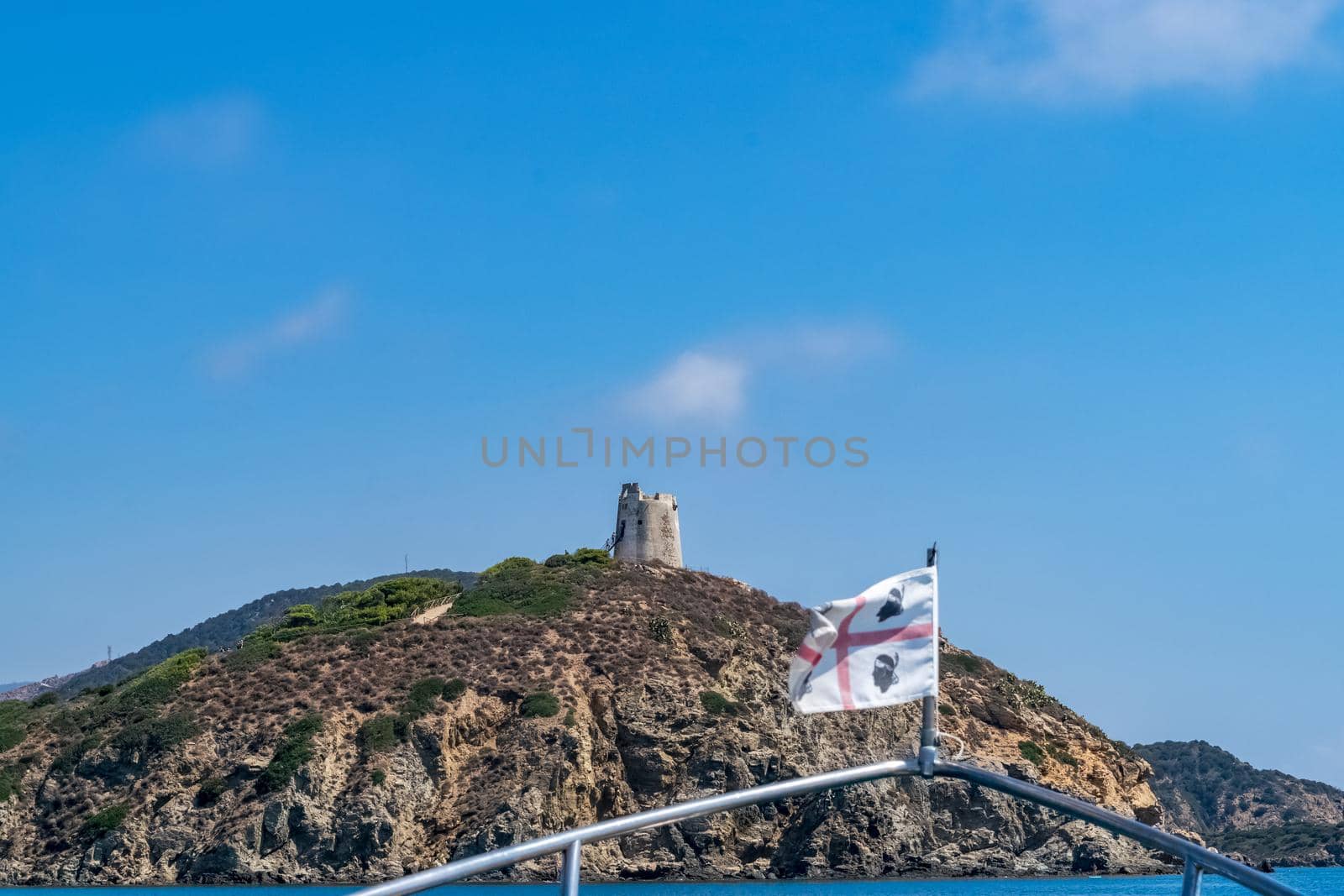 Beautiful view of the southern Sardinian sea from the boat. Note the historic Saracen tower on the rock formations.