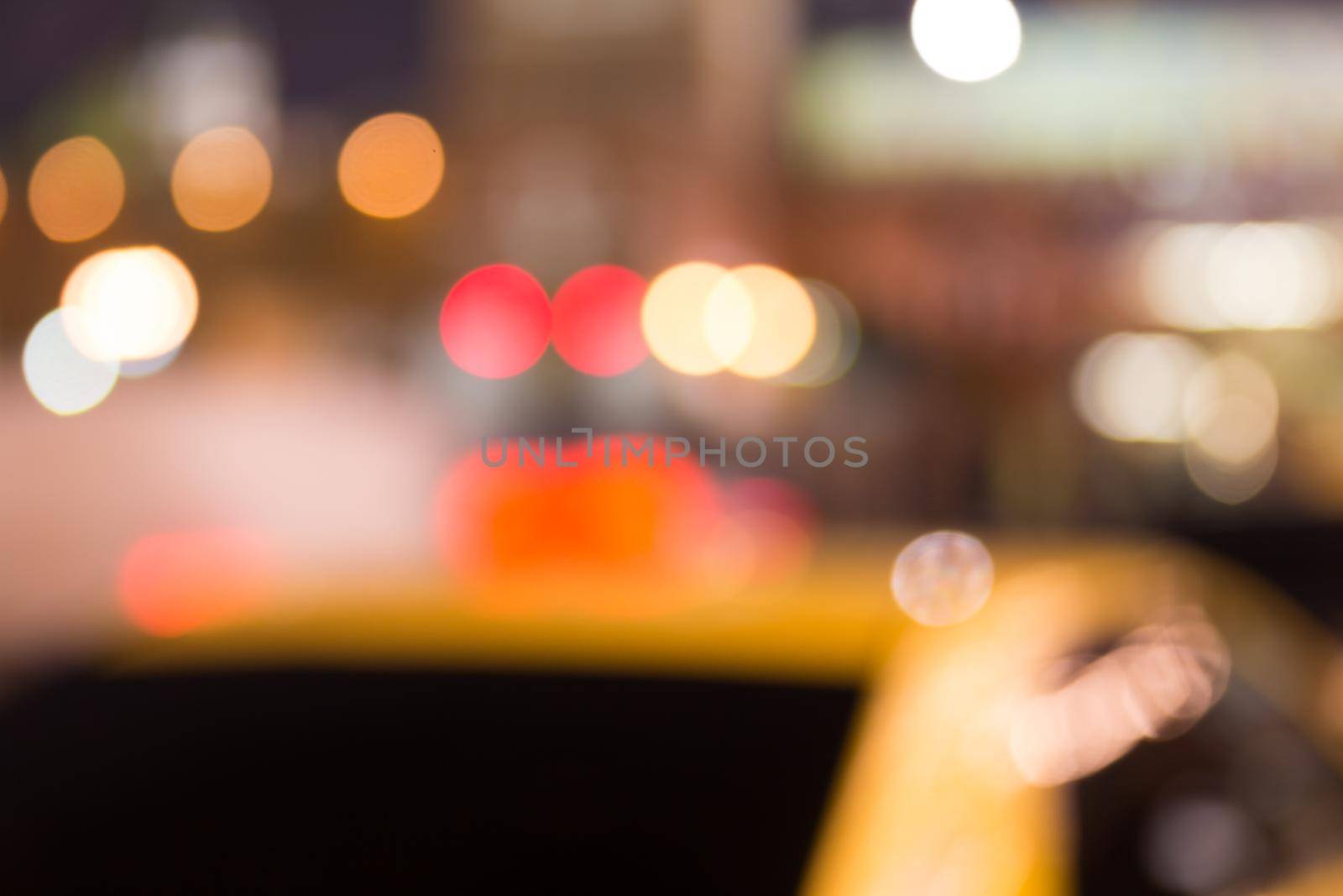 Busy city life blurred with taxi in foreground and street lights illuminating scene