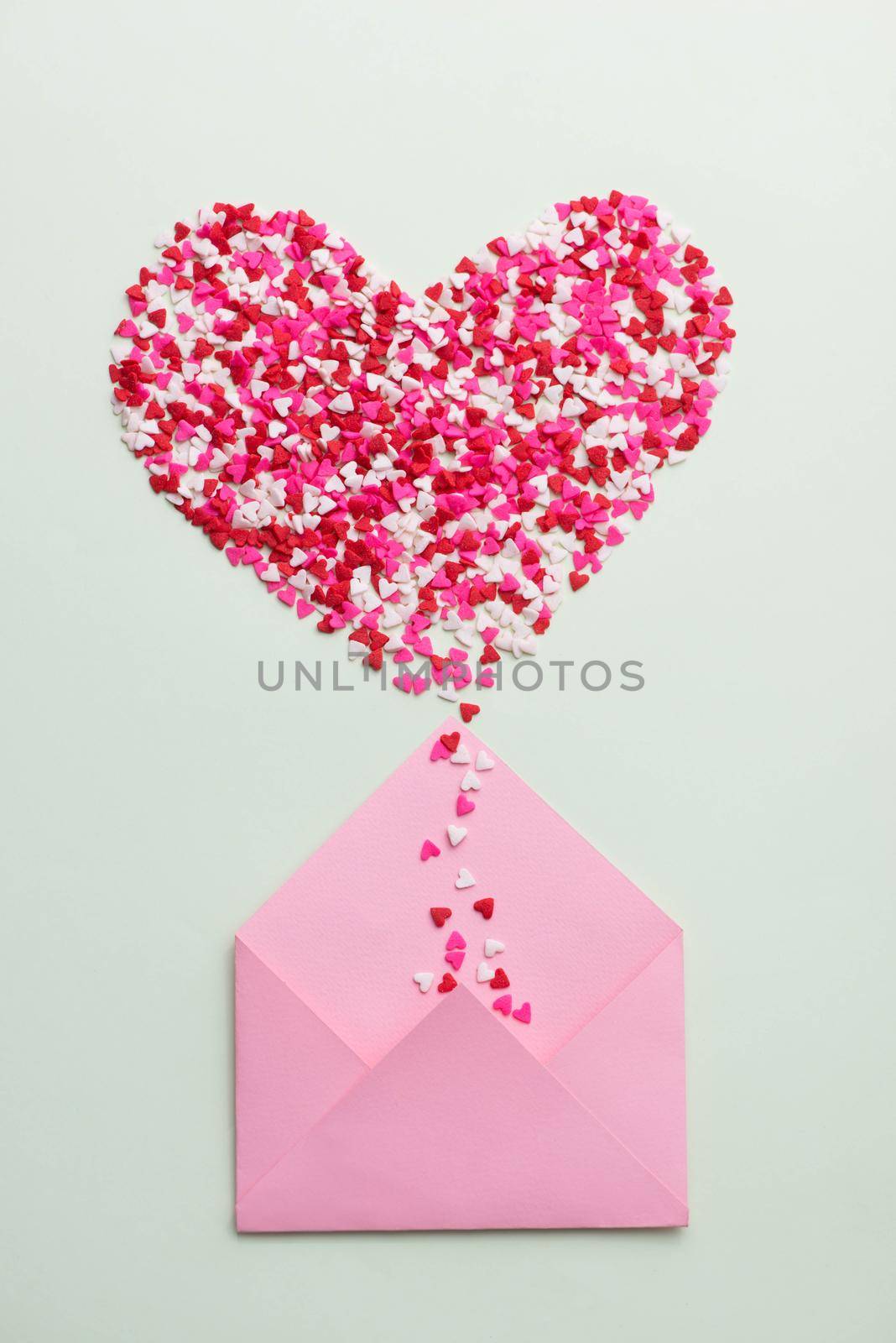 Sweets sugar candy hearts on envelope over green background by makidotvn