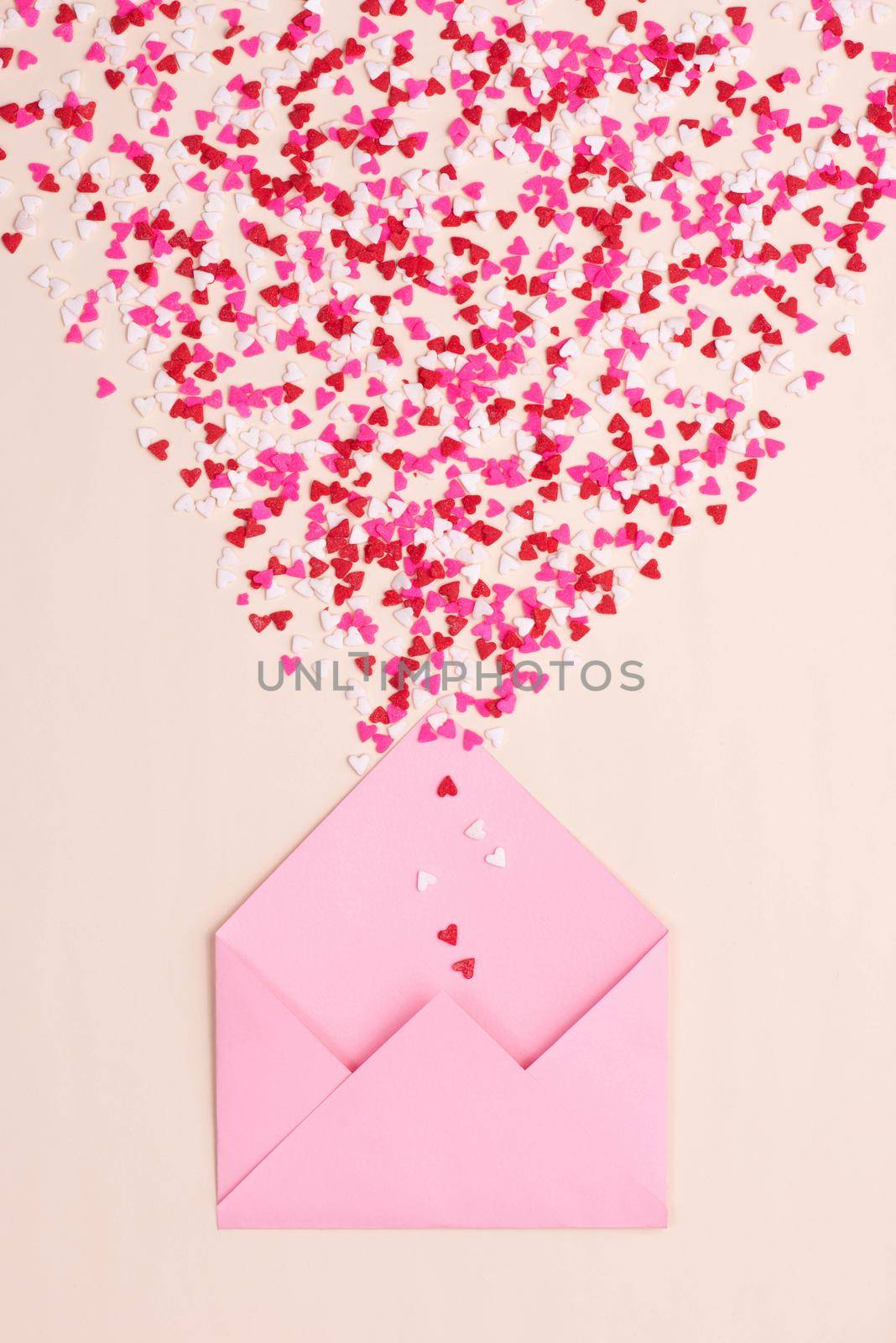 Sweets sugar candy hearts on envelope over green background