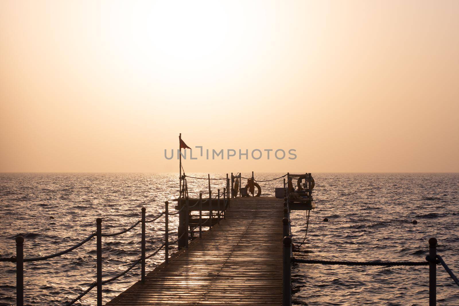 pier at dawn. against the background of the red sea by ja-aljona