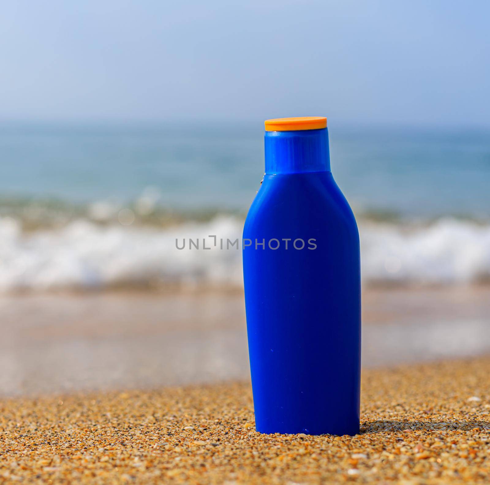 Sunburn milk on the background of the sea .Protection of the skin from the sun. Uniform tan. sfp . Beach holidays. Vacation at the sea . Sea wave