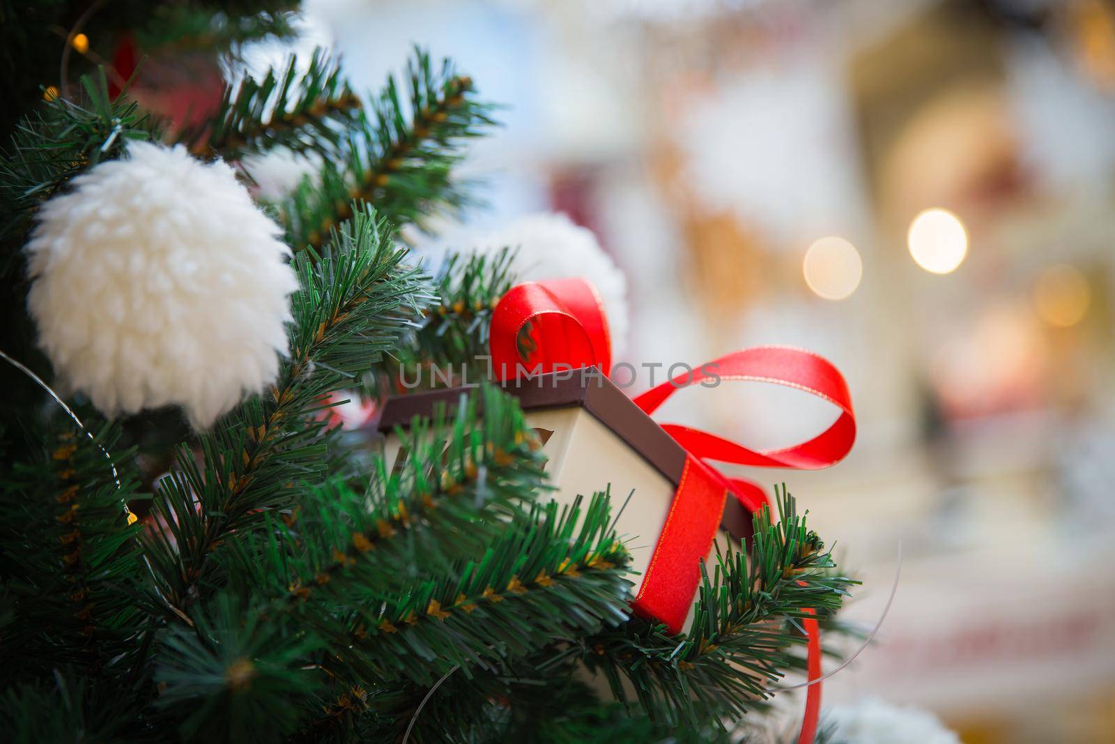 Present on a xmas tree in a box with red ribbon