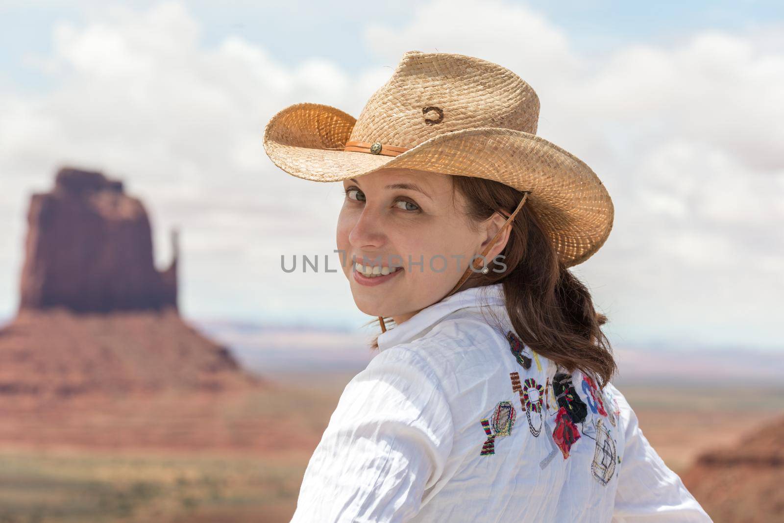 Young woman wearing straw hat in Monumet Valley looking back