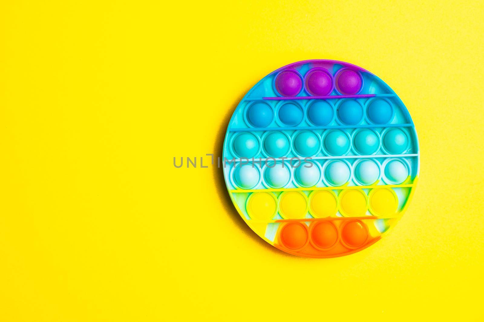 Pop it anti-stress on a yellow background. Modern toys. Toys for children. Silicone game. Autism. Trend. Copy space