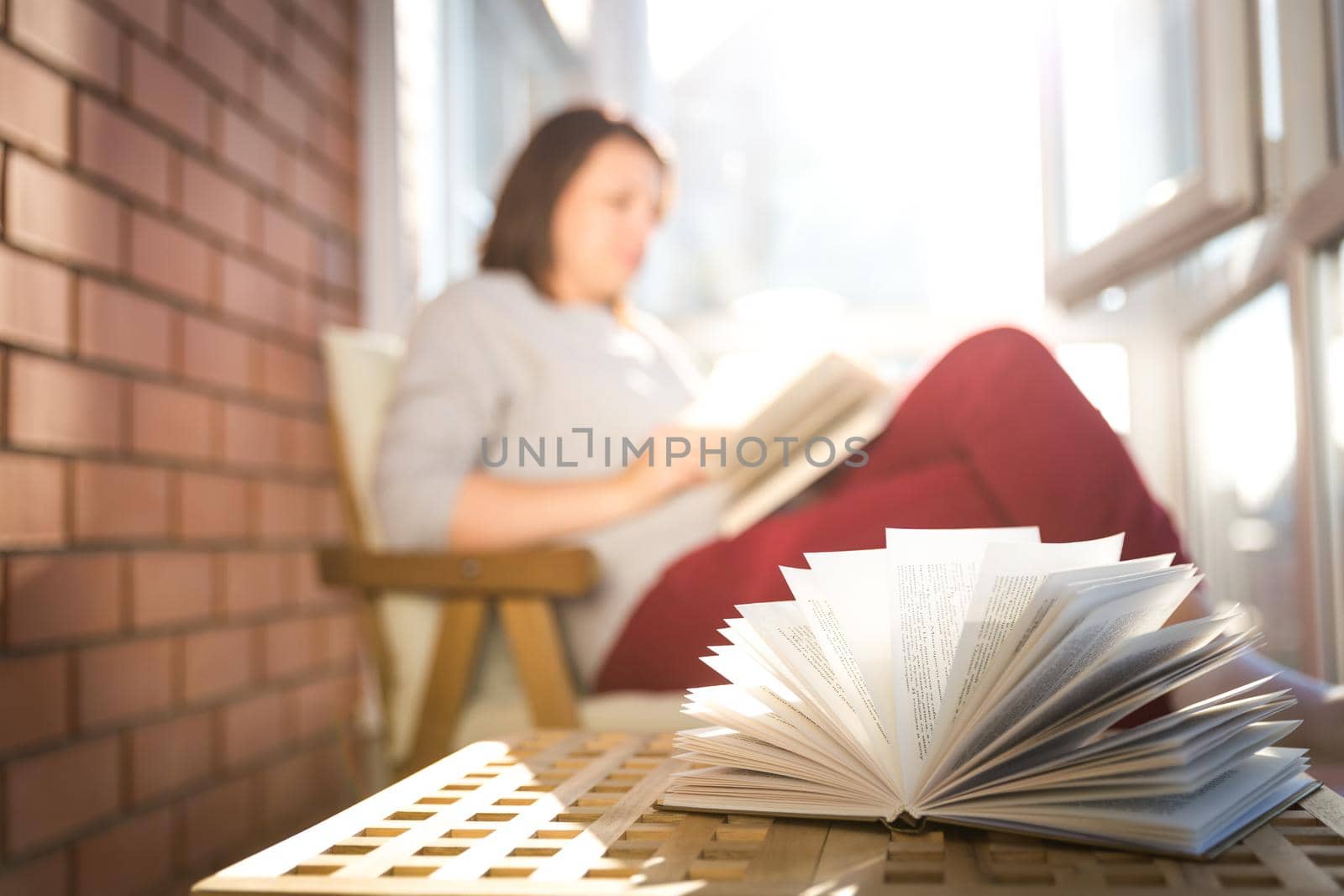 relaxed woman reading on balcony on a warm sunny day